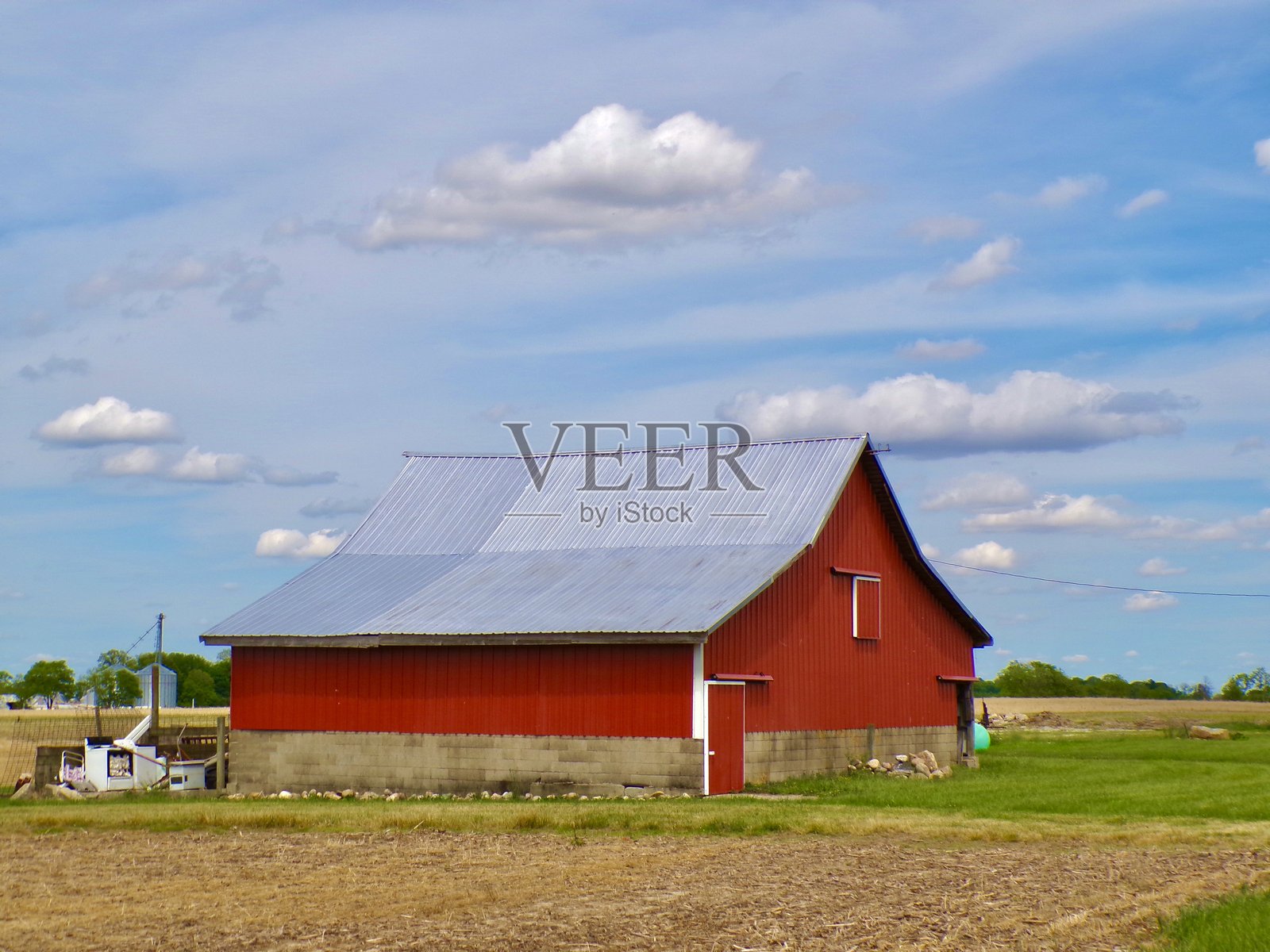 红色谷仓与蓝天和白云。照片摄影图片