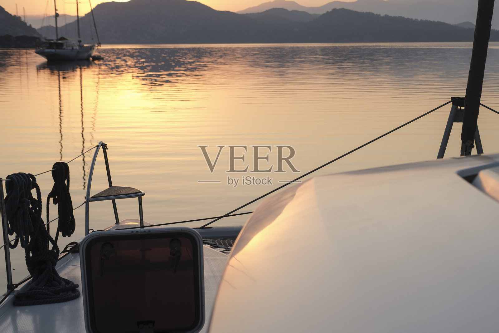 宁静的早晨日出美景,来自停泊船甲板,旭日东升,山脉,海面光影,黄昏色彩,帆船,宁静的港口照片摄影图片