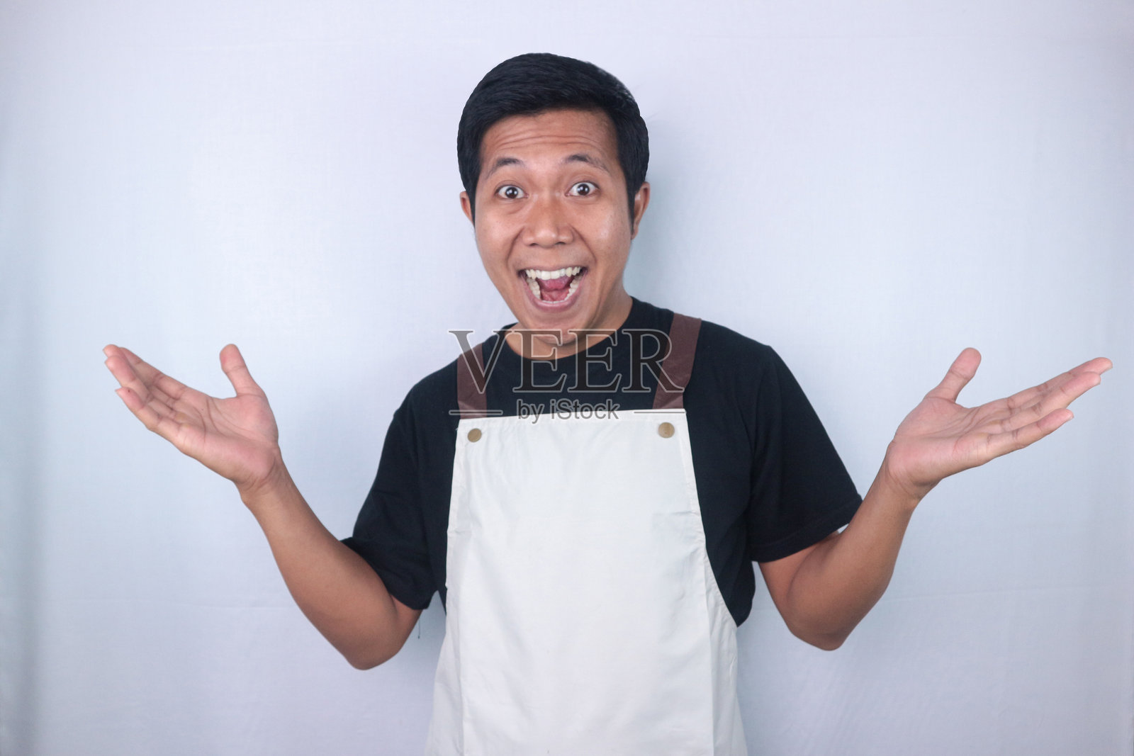 搞笑的震惊表情年轻亚洲男子,咖啡师,酒保,双手摊开照片摄影图片