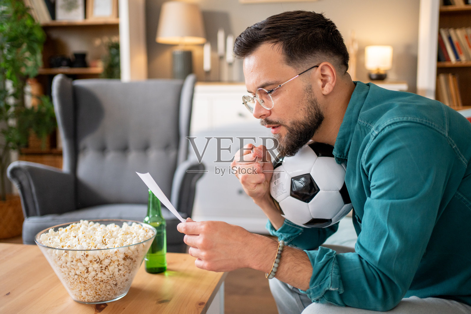 足球迷在家中查看体育博彩结果照片摄影图片