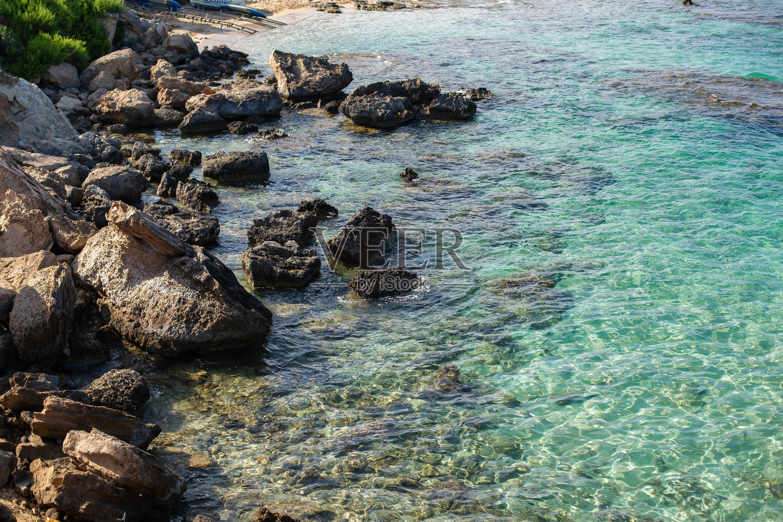 塞浦路斯阳光明媚的日子里,岩石海岸线与清澈的碧绿色海水。照片摄影图片