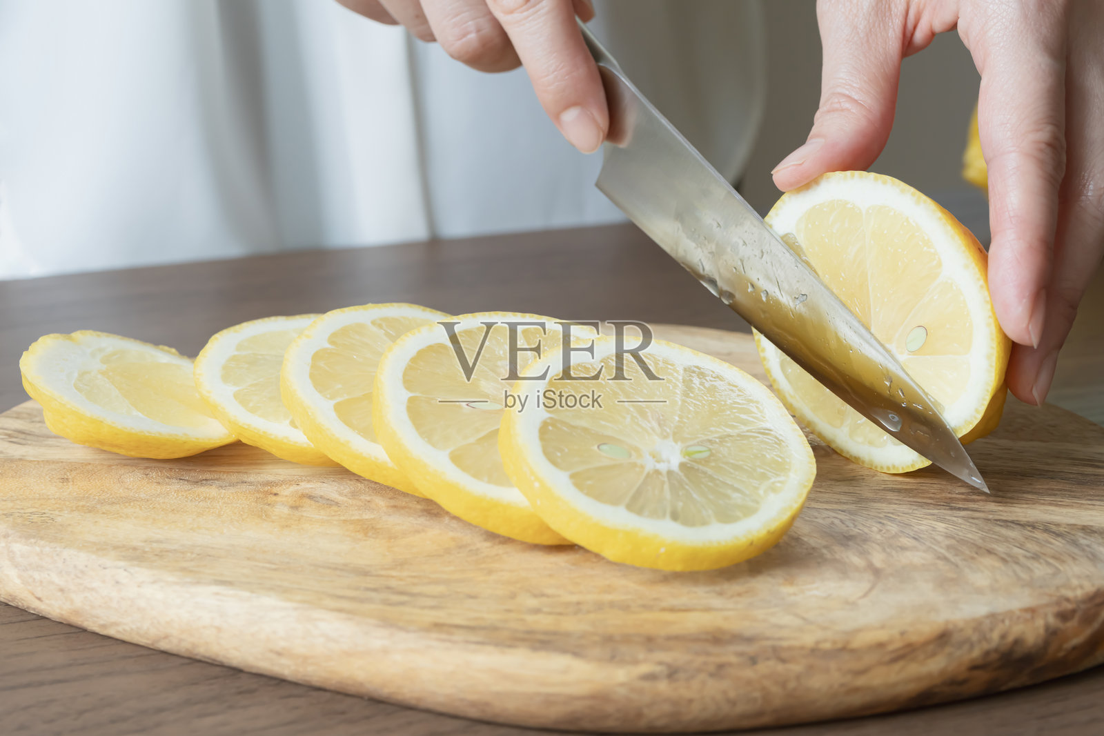 柠檬片。用刀切柠檬。照片摄影图片