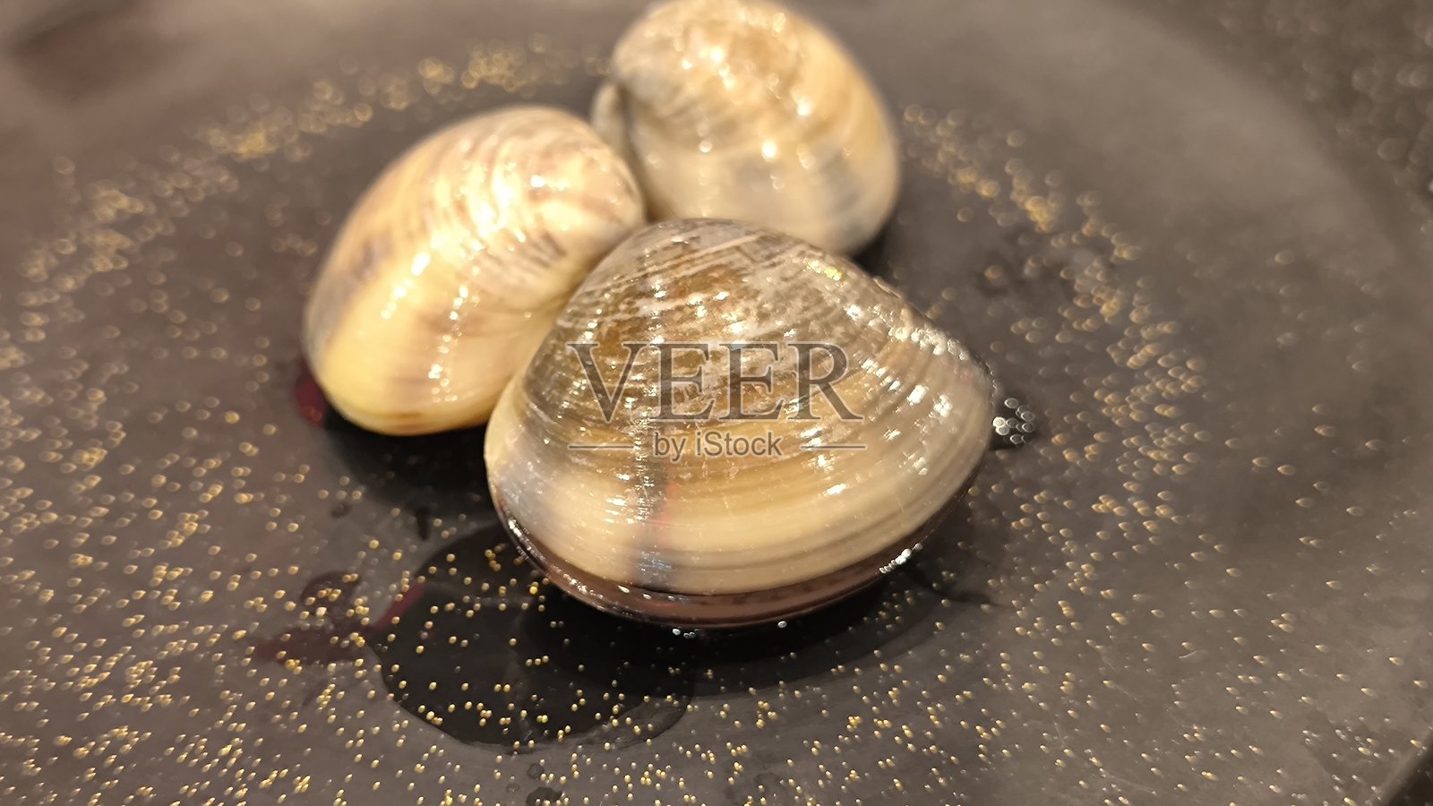 黑色盘子上的蛤蜊。天然食品。照片摄影图片