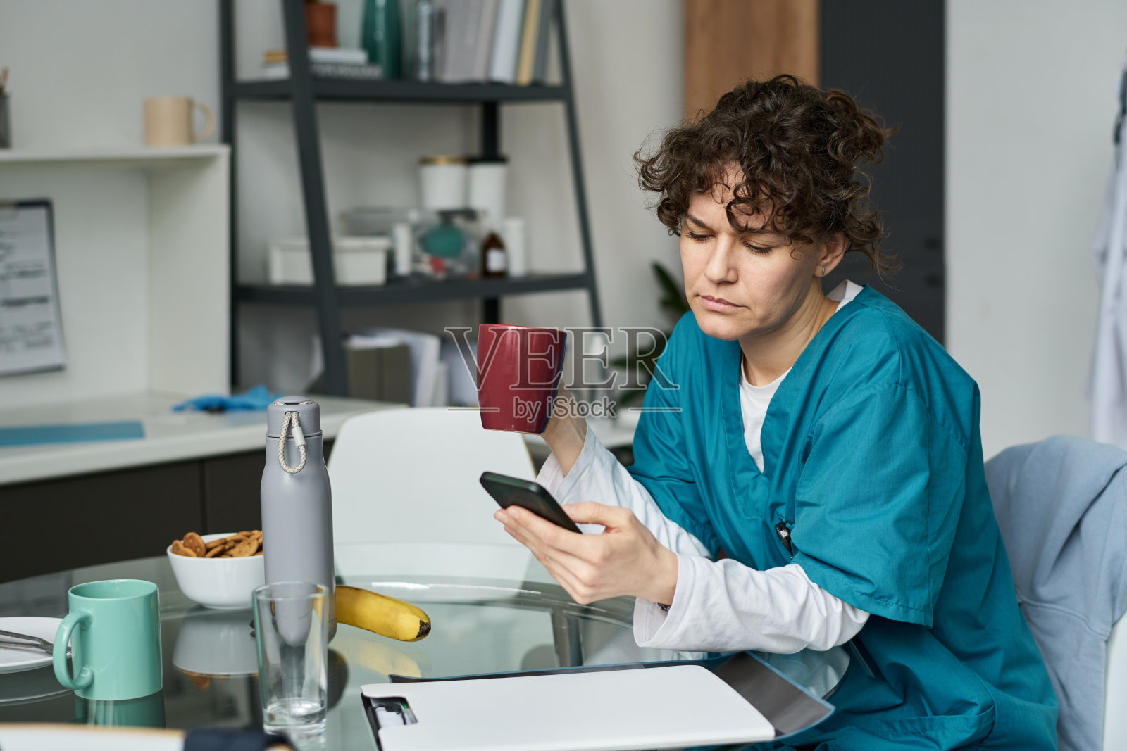 女性医疗工作者在休息期间查看智能手机照片摄影图片