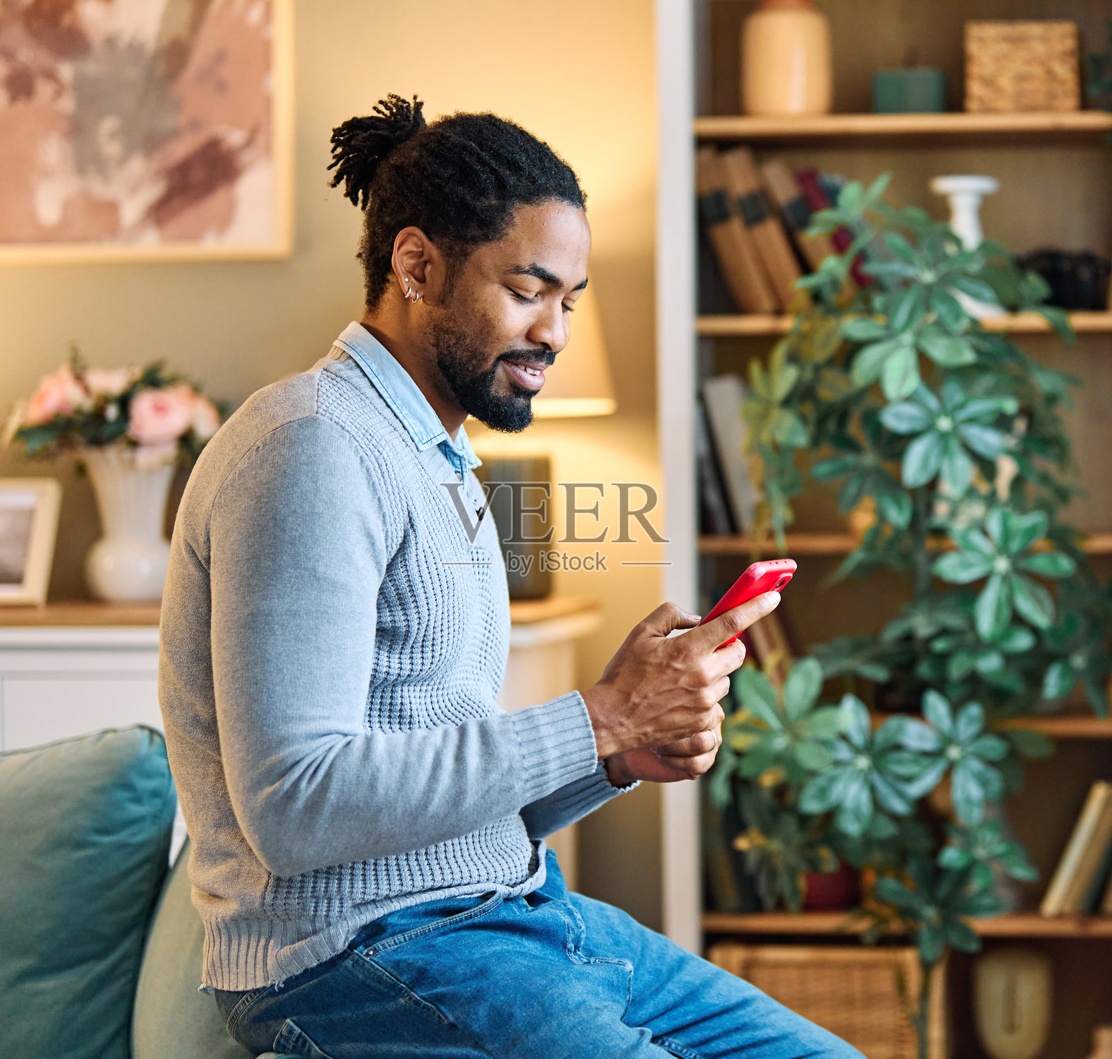 年轻男子在使用手机进行通话,面带微笑,享受着愉快的交流时光。照片摄影图片