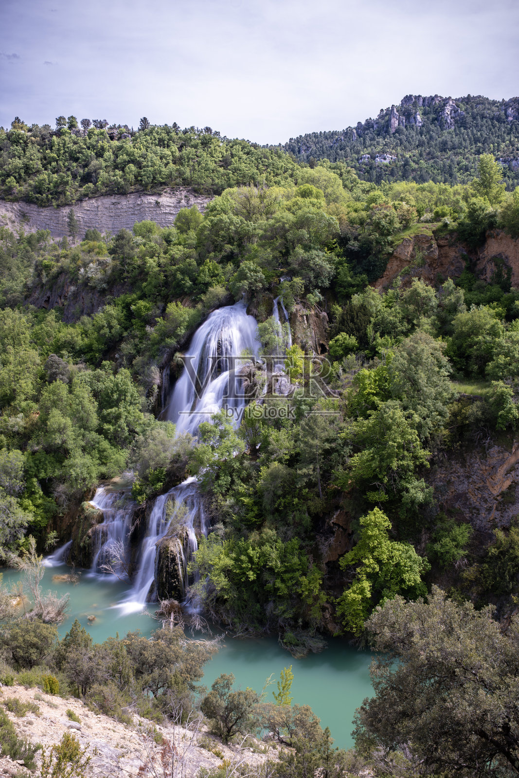 在瓜达拉哈拉的阿尔托塔霍自然公园,坎皮略瀑布的水流穿过郁郁葱葱的植被,呈垂直状态。照片摄影图片