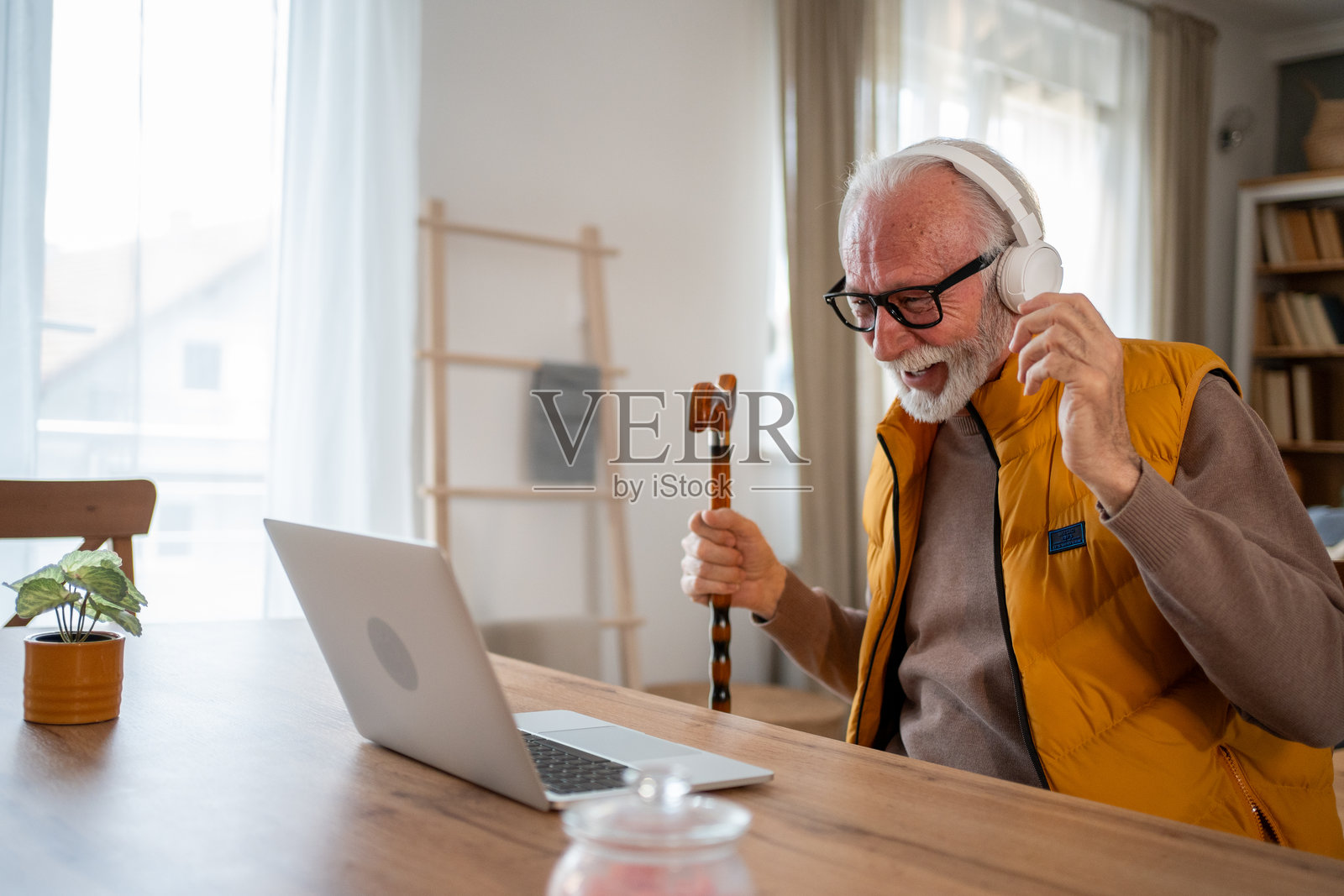 老年男子用拐杖当麦克风在线唱卡拉OK照片摄影图片