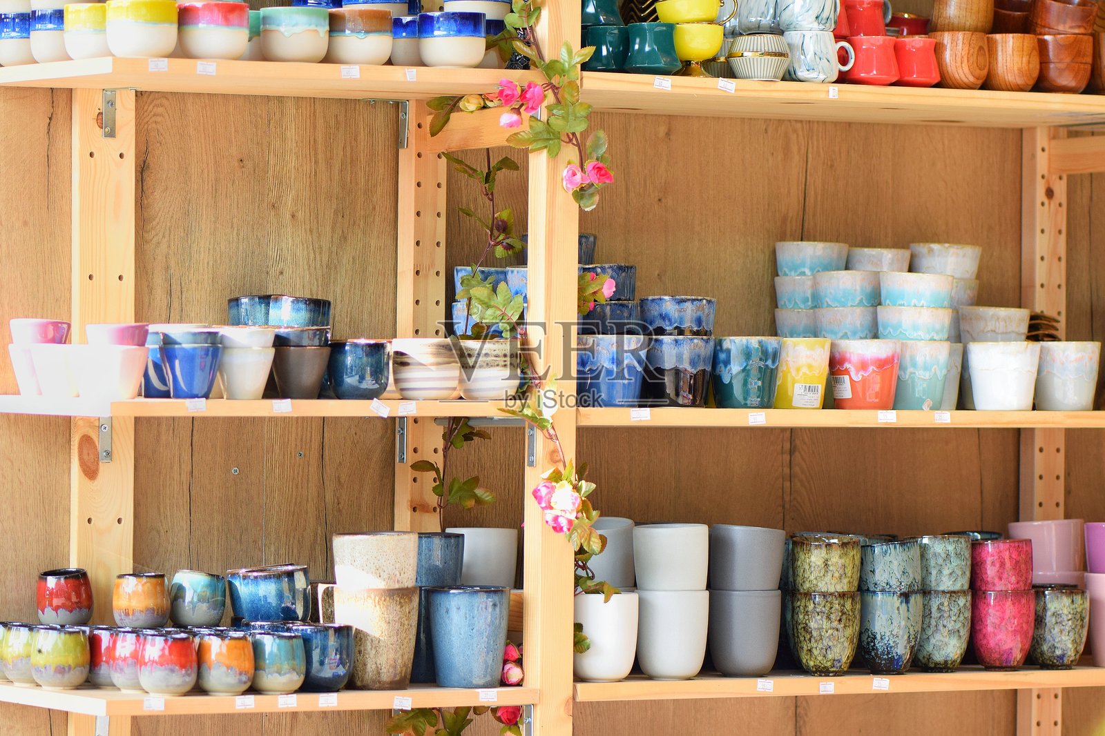 色彩斑斓的陶瓷杯和罐子陈列在展示架上照片摄影图片
