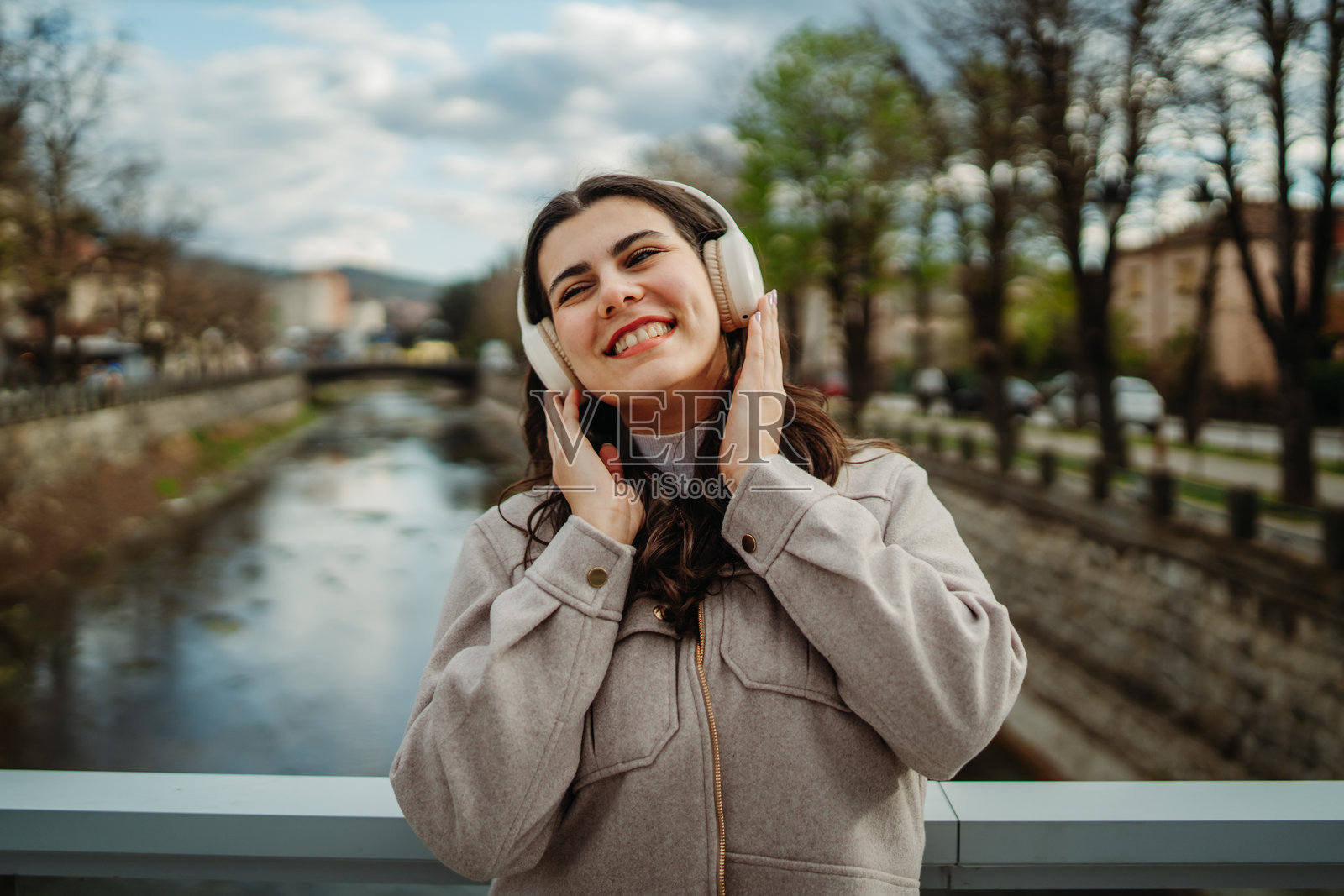 年轻的白人女性戴着无线耳机听音乐照片摄影图片