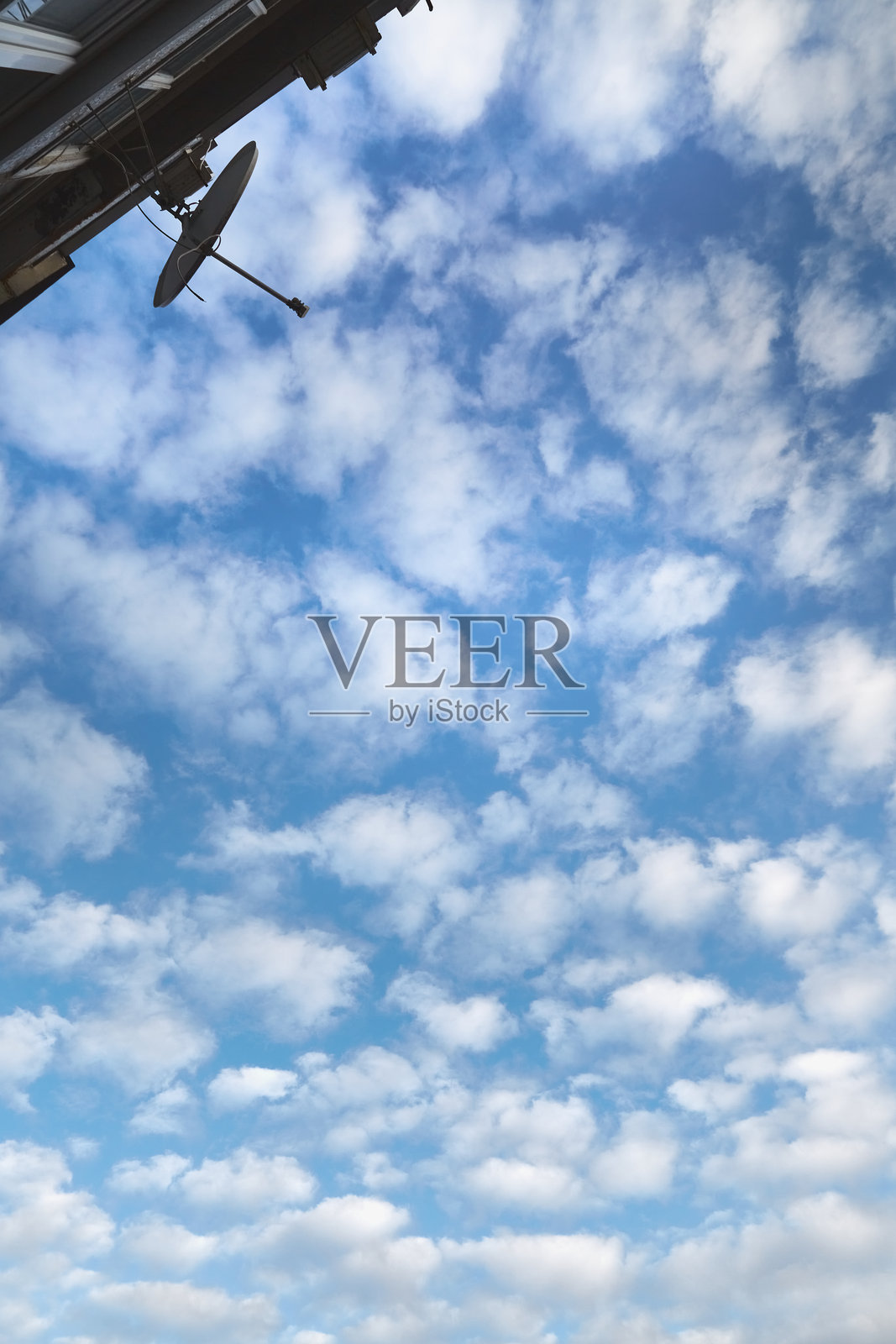 房子墙上的卫星天线,背景是白云的天空,直播、卫星通信和直接电视传输。照片摄影图片