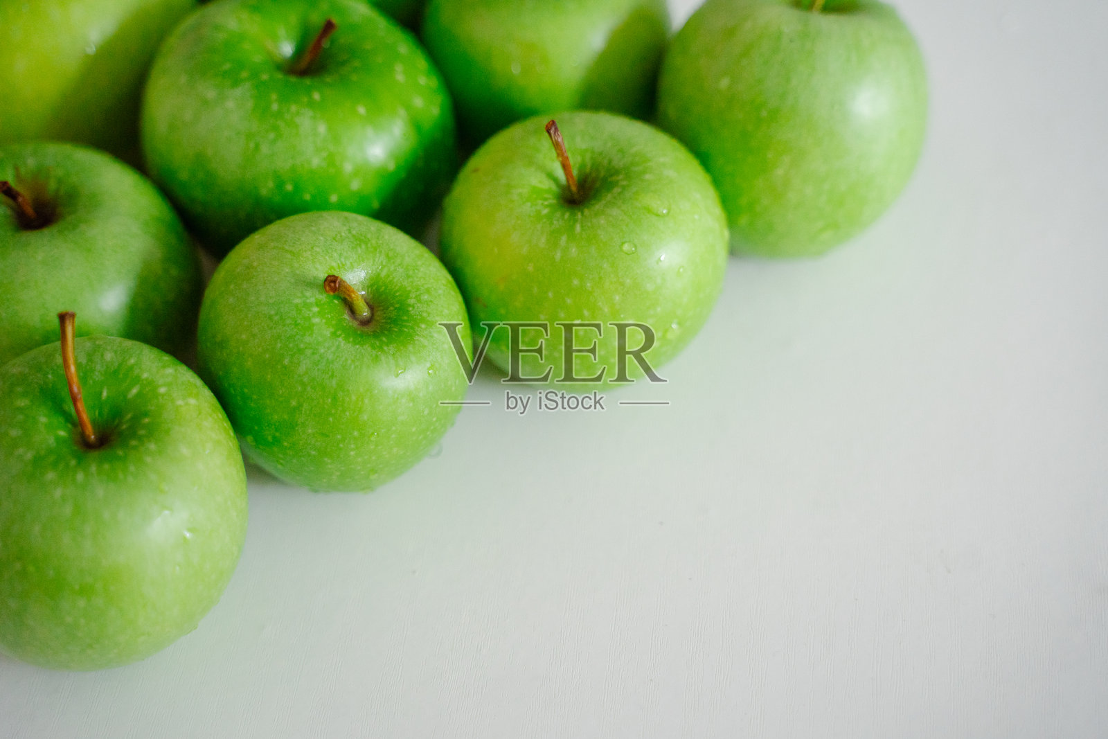 一组绿色苹果摆放在干净的背景上。它们鲜艳的颜色突出,唤起一种清新的感觉,非常适合任何食谱。照片摄影图片