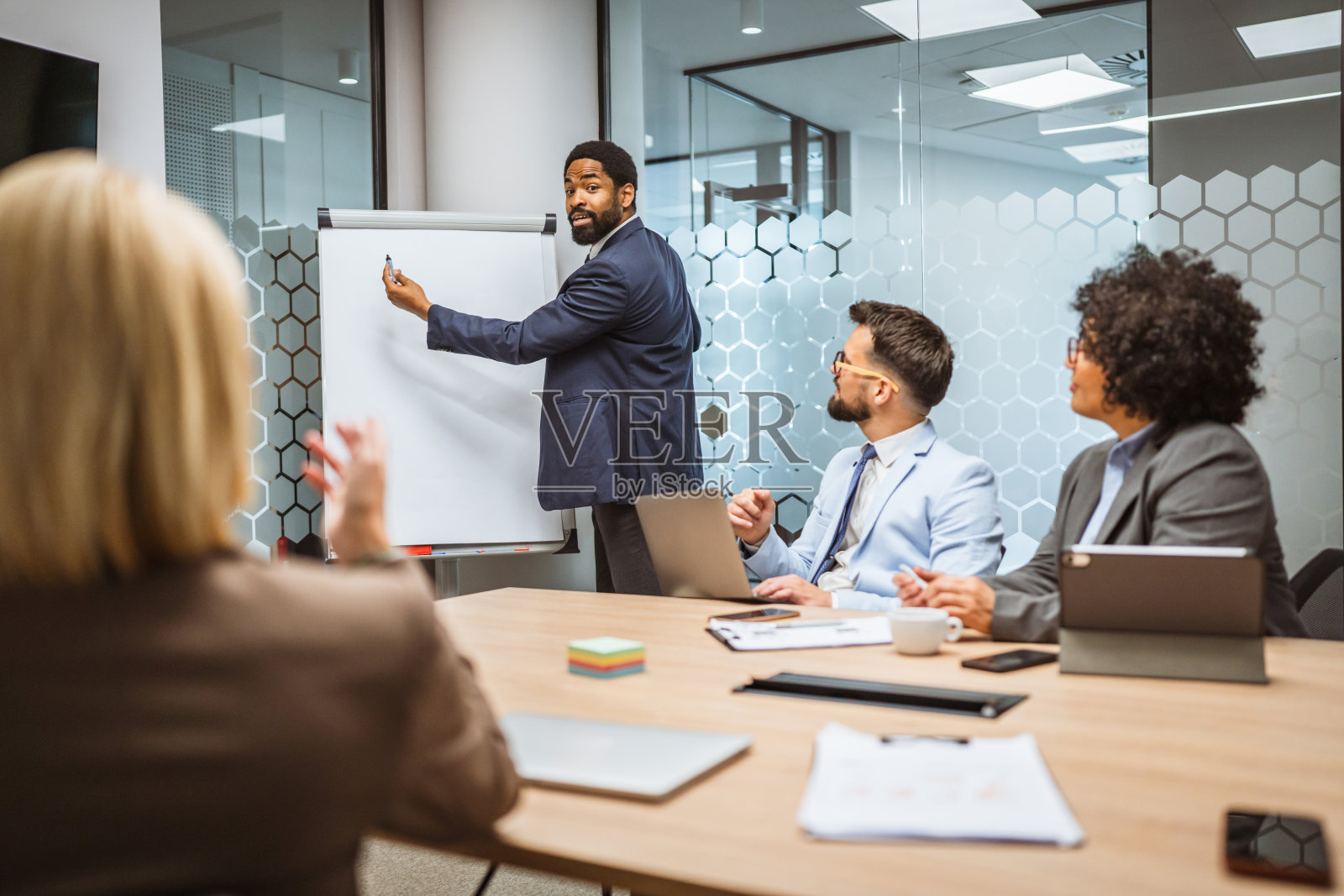 专注的商人在办公室向同事们做演讲照片摄影图片