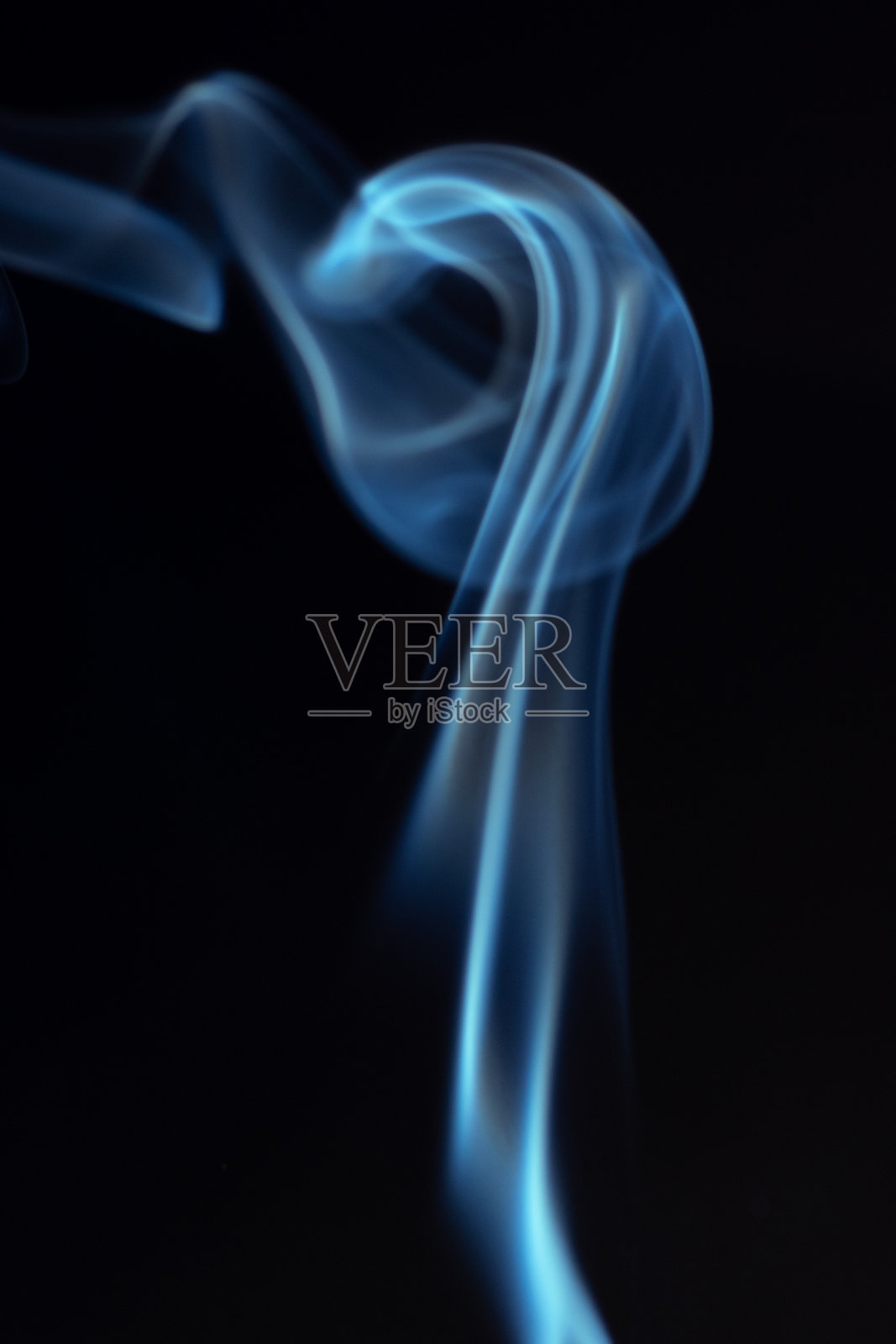 细腻的蓝色烟雾在黑暗背景上优雅地旋转,形成一种抽象而飘渺的视觉效果,展现流动的动感。神秘与创造力的概念。旋转、扭动的烟雾可用于叠加在您的照片上。照片摄影图片