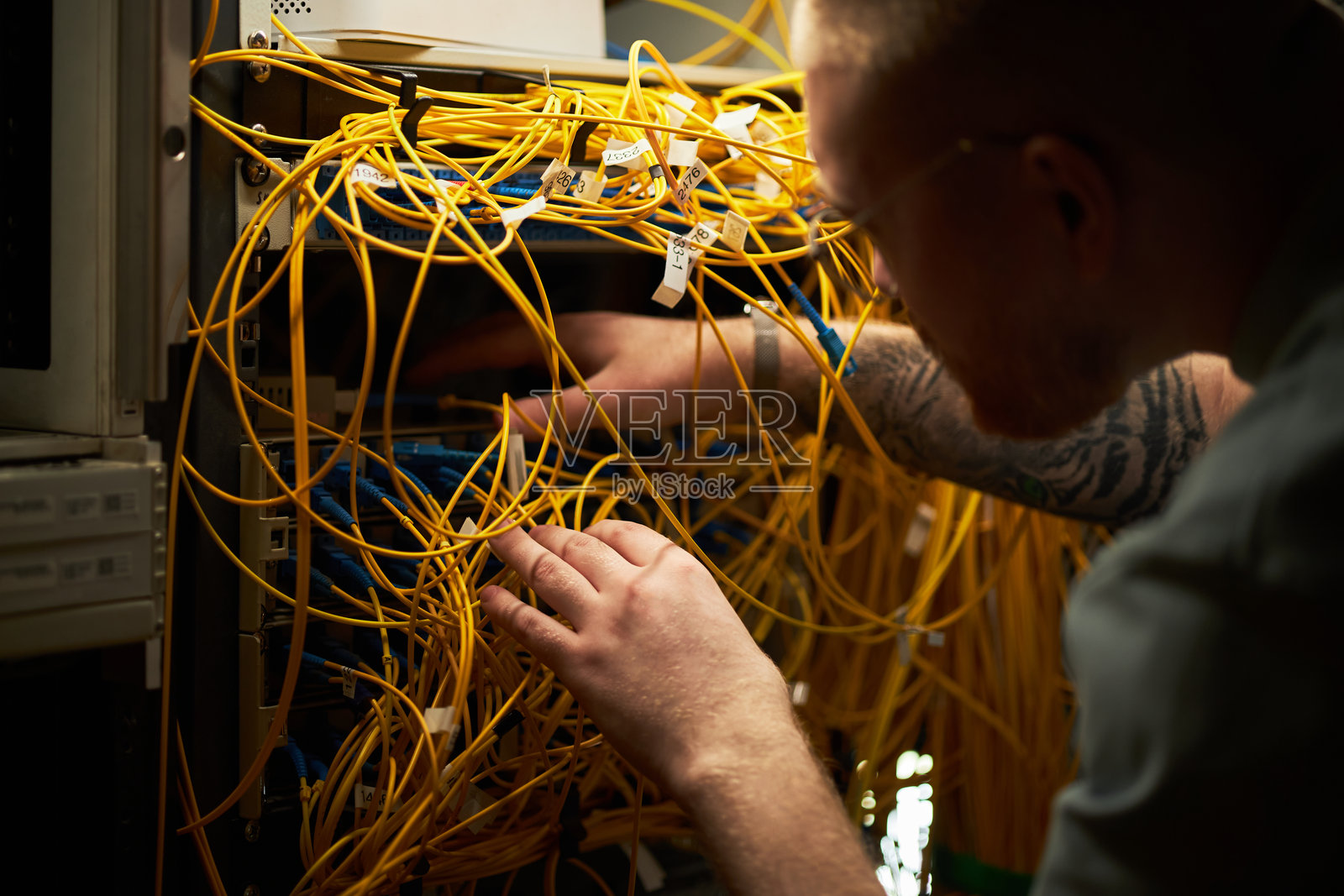 男子在服务器机房测试网络电缆照片摄影图片