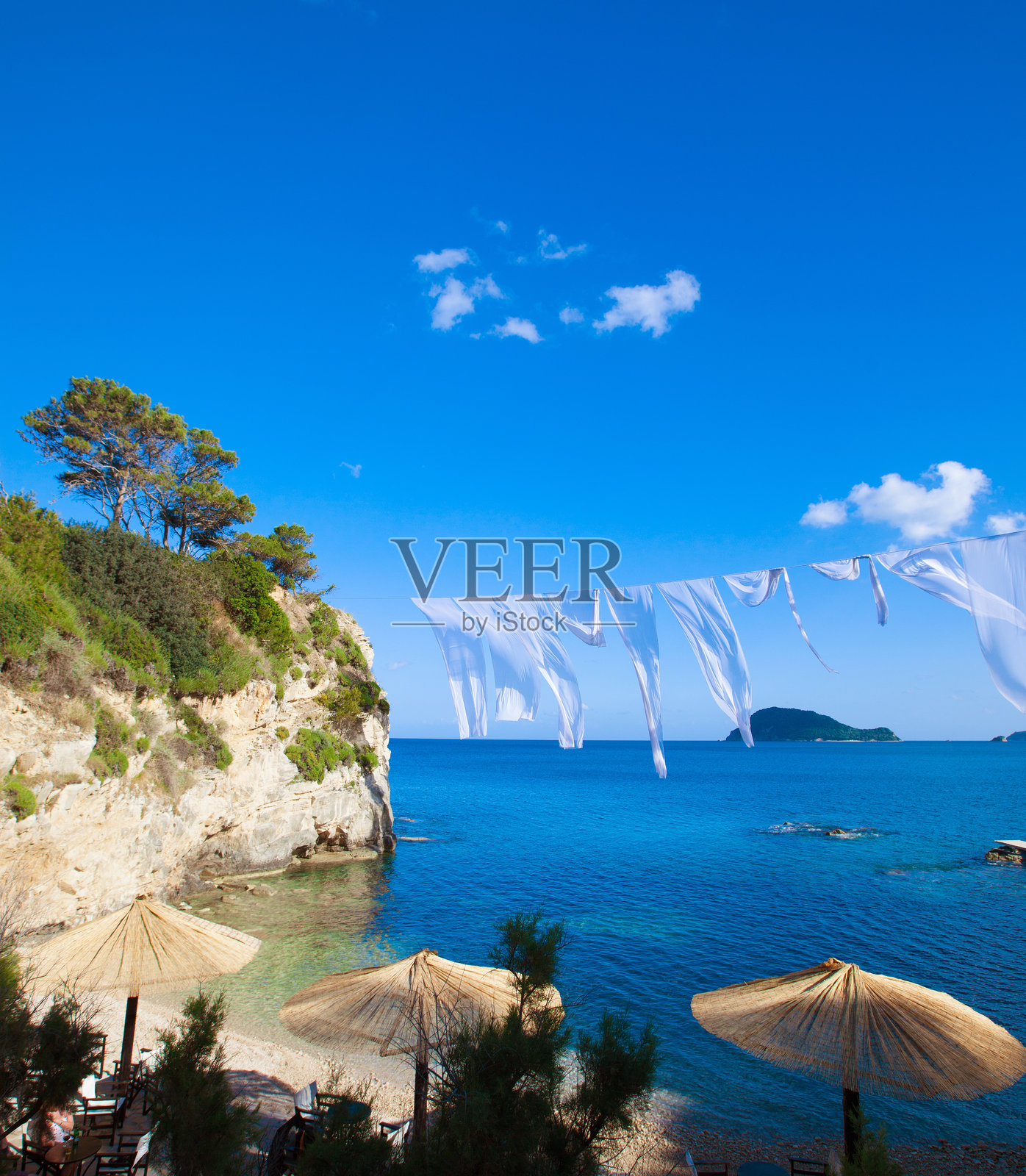 海滩上的一排草伞和躺椅照片摄影图片