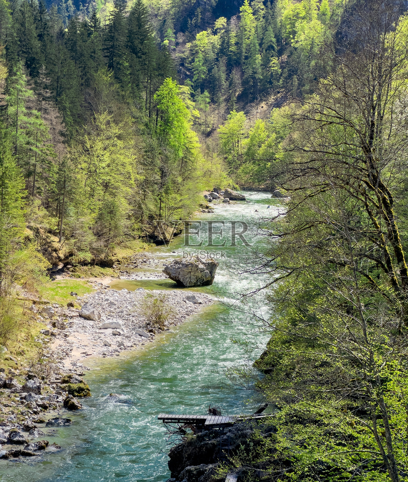 从悬索桥俯瞰流经阿尔卑斯山脉的河流照片摄影图片
