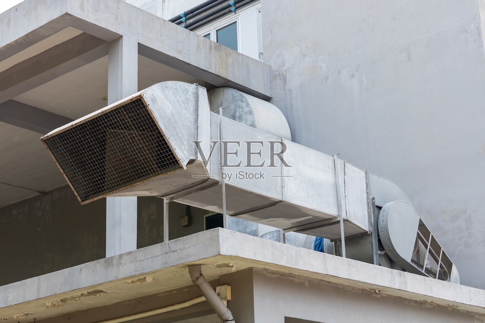 建筑外部屋顶上的钢制空气管道。照片摄影图片