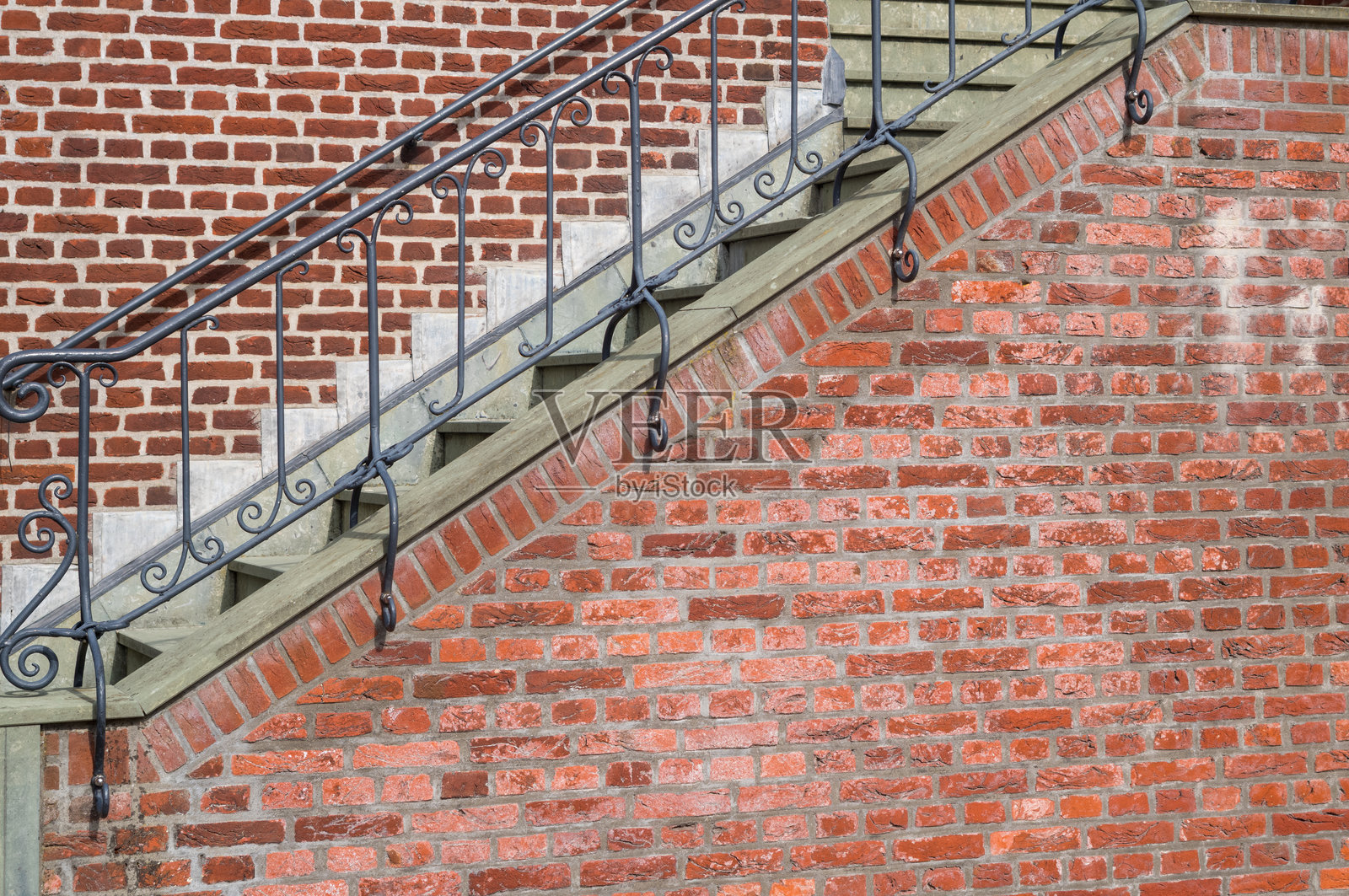 砖墙旁的户外楼梯,配有锻铁栏杆照片摄影图片