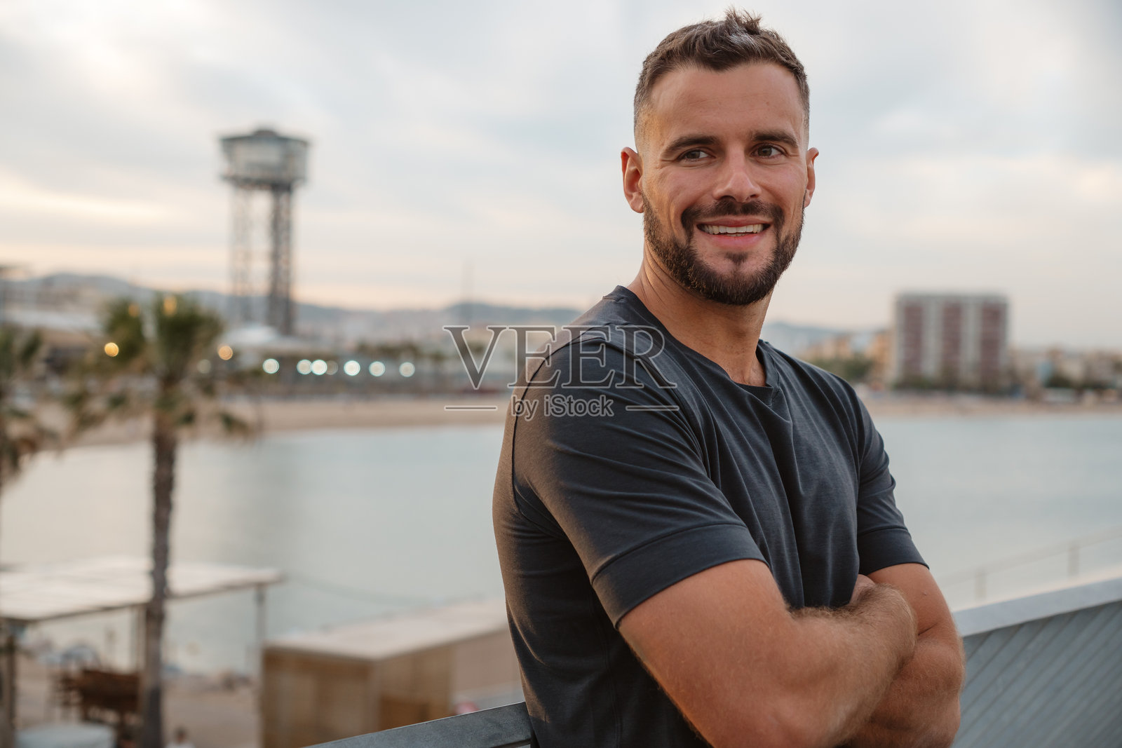 自信的企业家在巴塞罗那微笑,双臂交叉。照片摄影图片