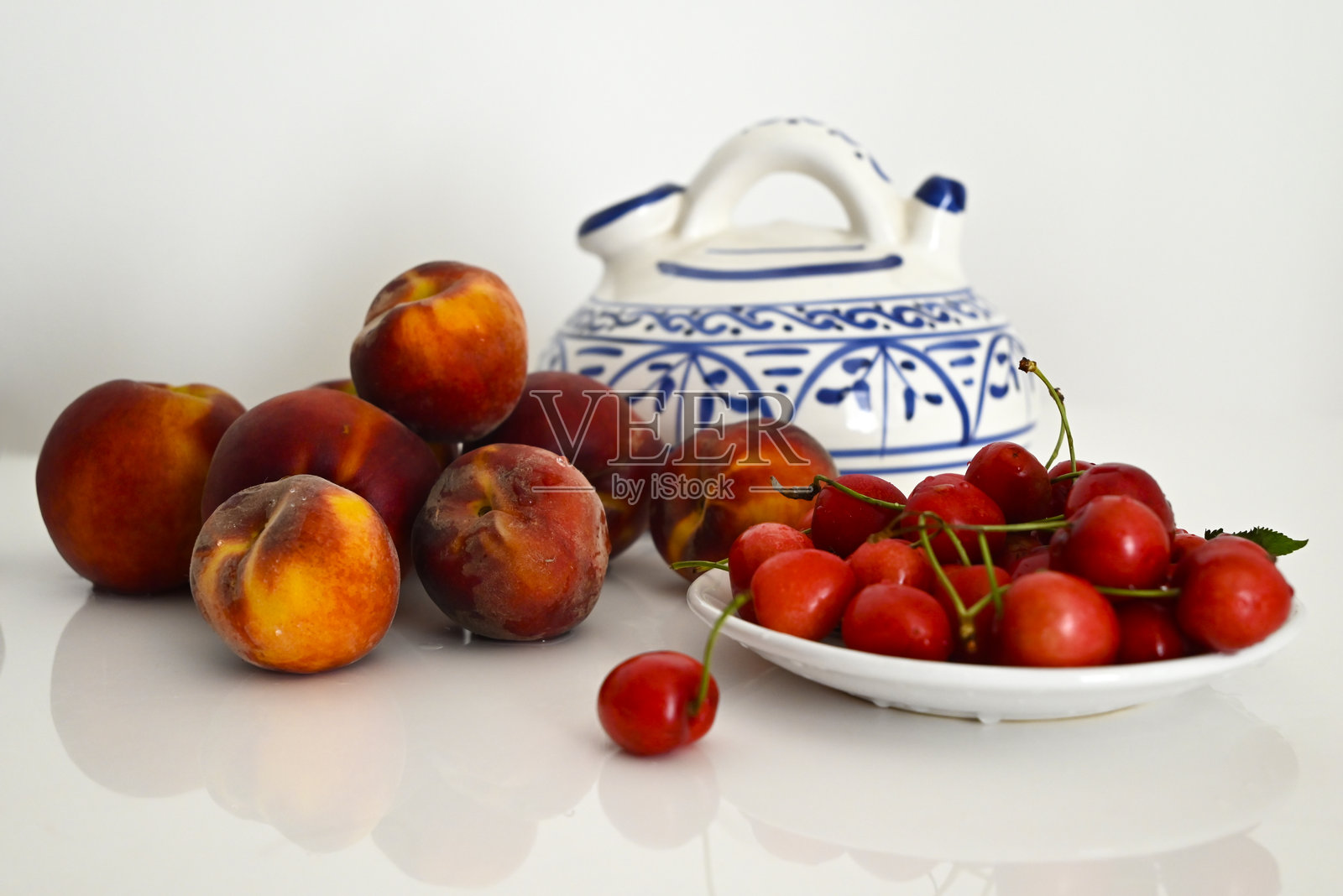 桃子和樱桃与钴蓝色陶瓷壶 – 乡村水果静物画照片摄影图片