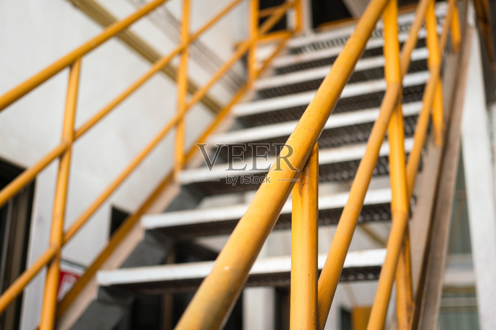 楼梯平台的栏杆手扶梯,涂有黄色油漆。照片摄影图片