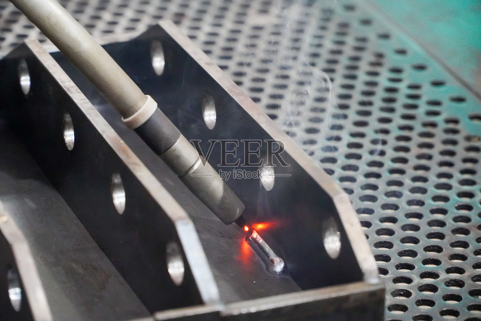 工业机器人正在焊接,机器人在焊接汽车零部件的移动。照片摄影图片