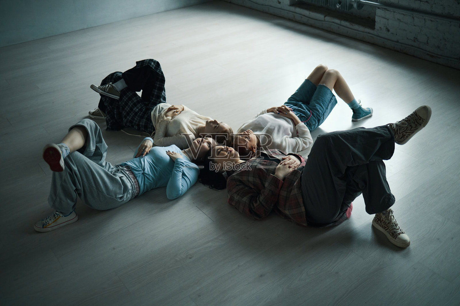 人们在现代空间里躺在地板上放松照片摄影图片