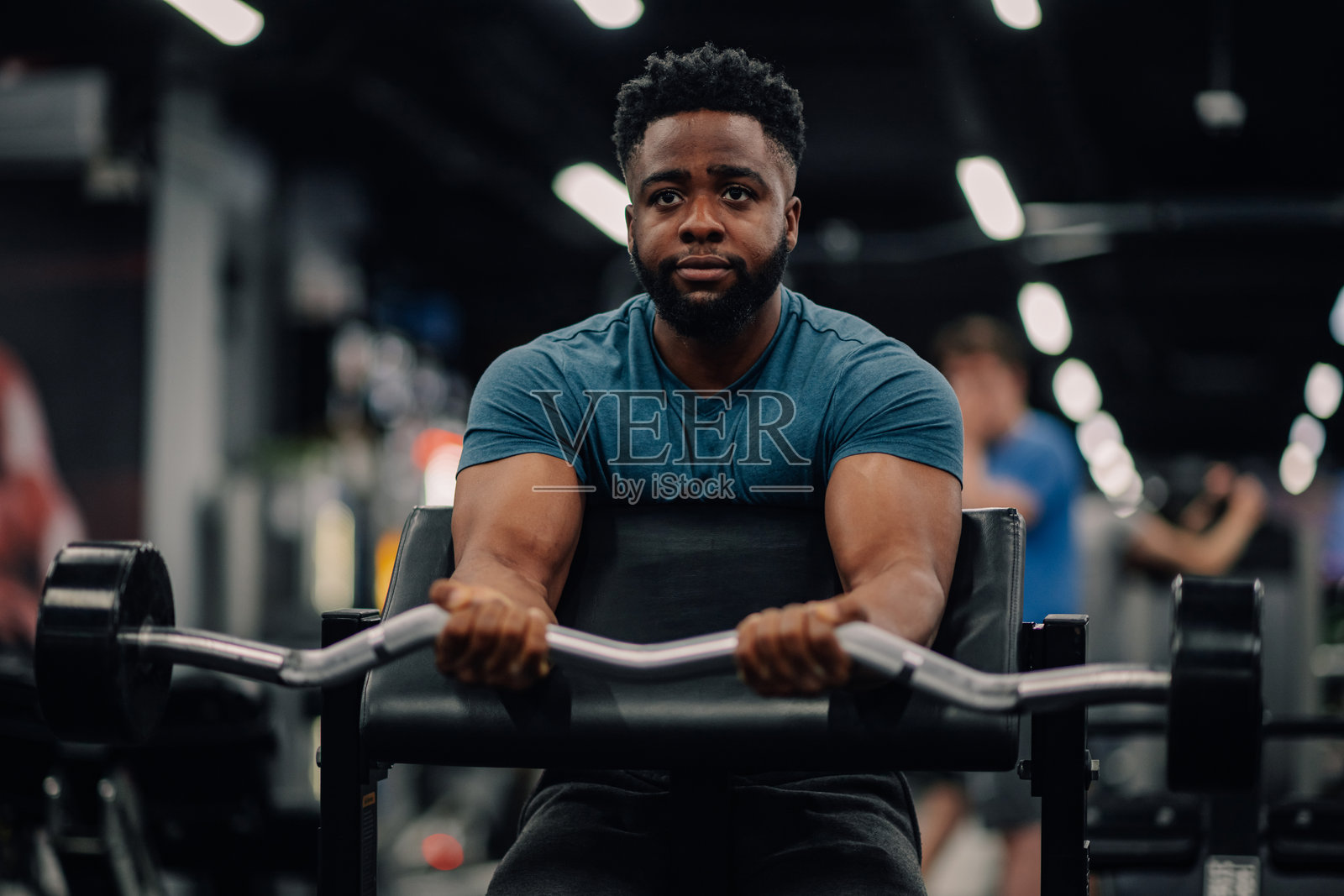 决心坚定的健美运动员在健身房举重锻炼二头肌照片摄影图片