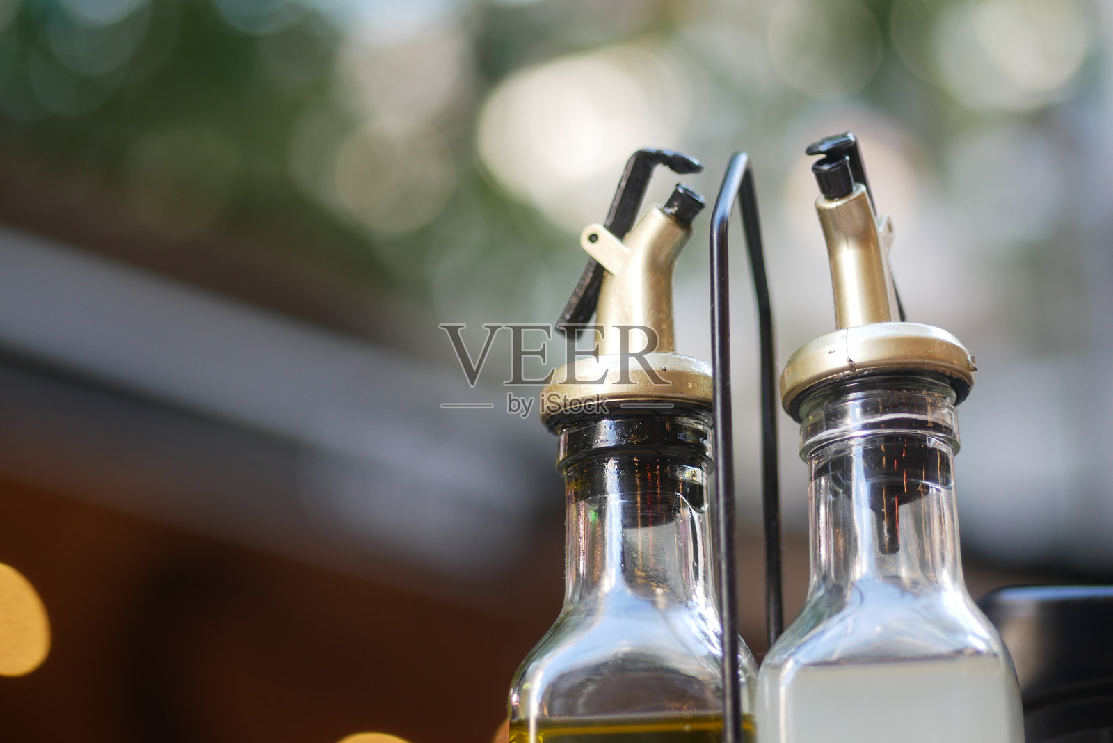温馨户外咖啡馆环境中的橄榄油和醋分配器照片摄影图片