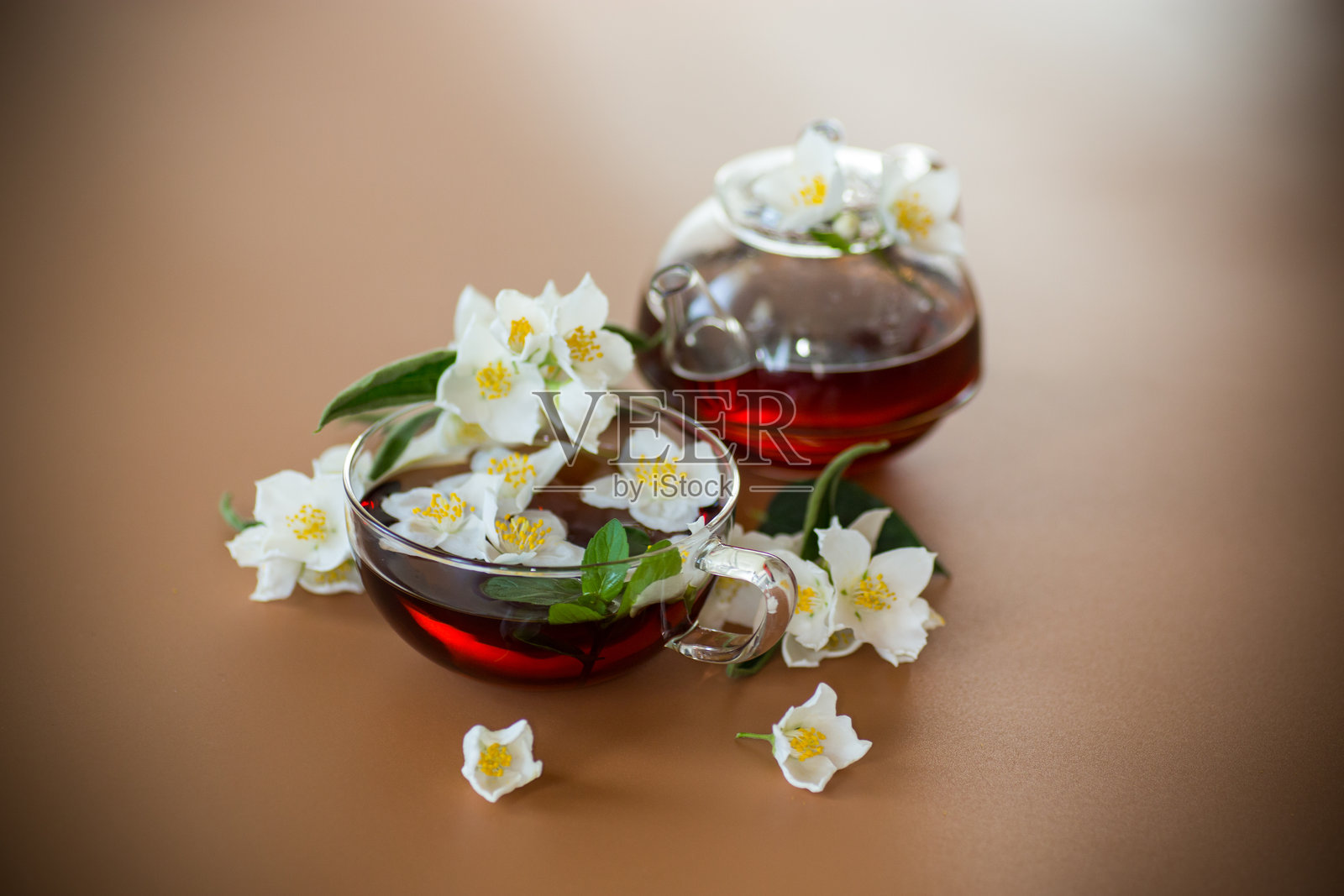 天然绿茶与茉莉花瓣在棕色背景上照片摄影图片