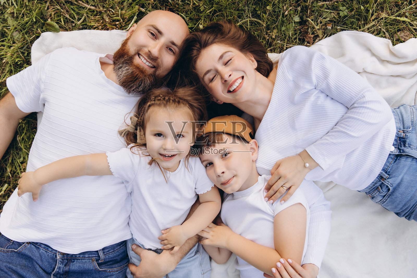 快乐的家庭在公园的毯子上享受夏日时光照片摄影图片