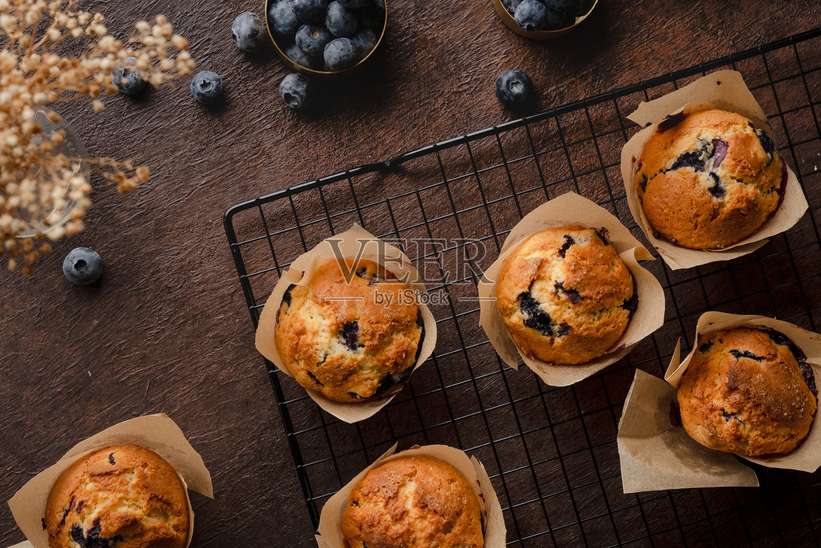 新鲜蓝莓松饼在冷却架上,木质表面俯视图照片摄影图片