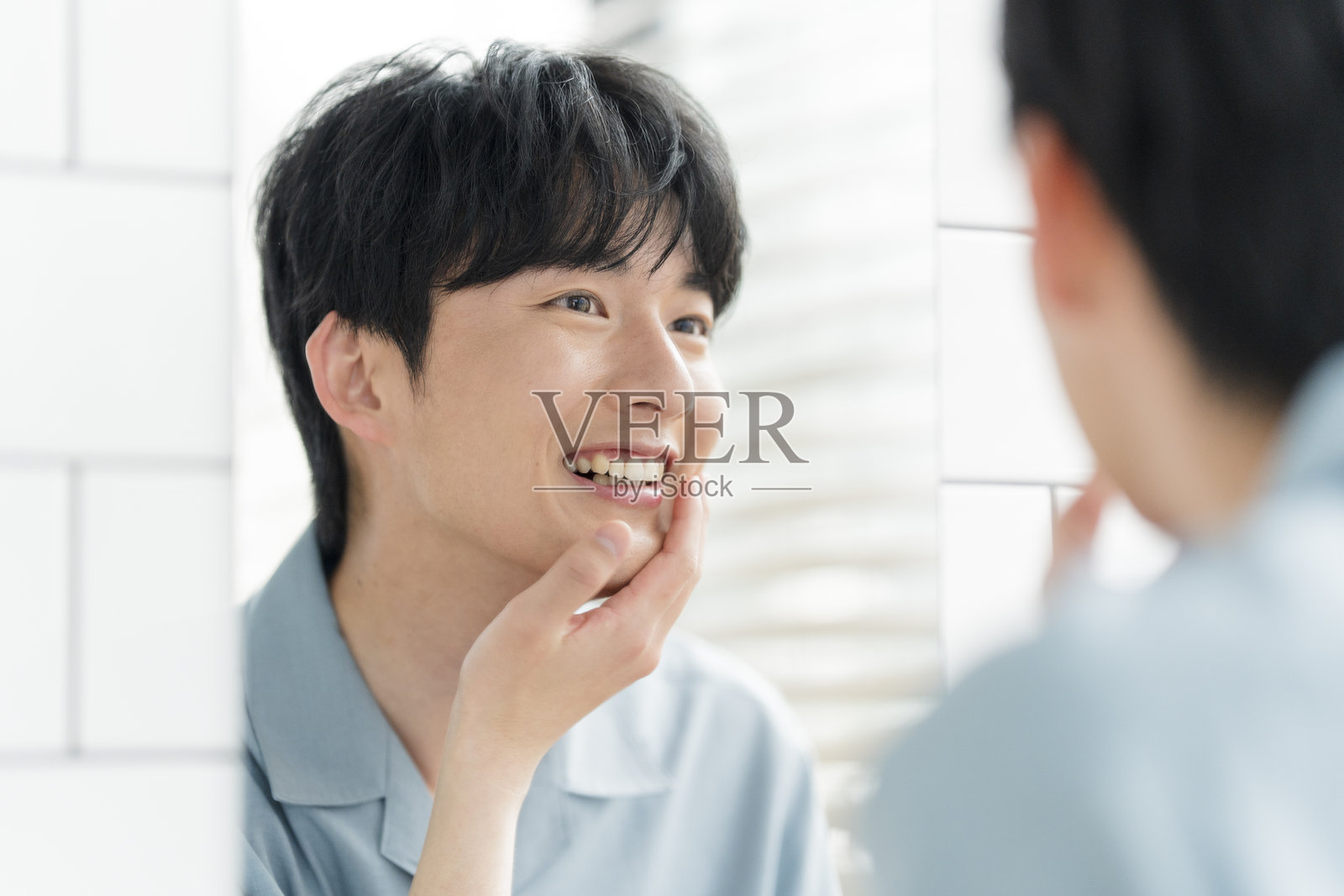 一位年轻的日本男子在家里的浴室里打理自己照片摄影图片