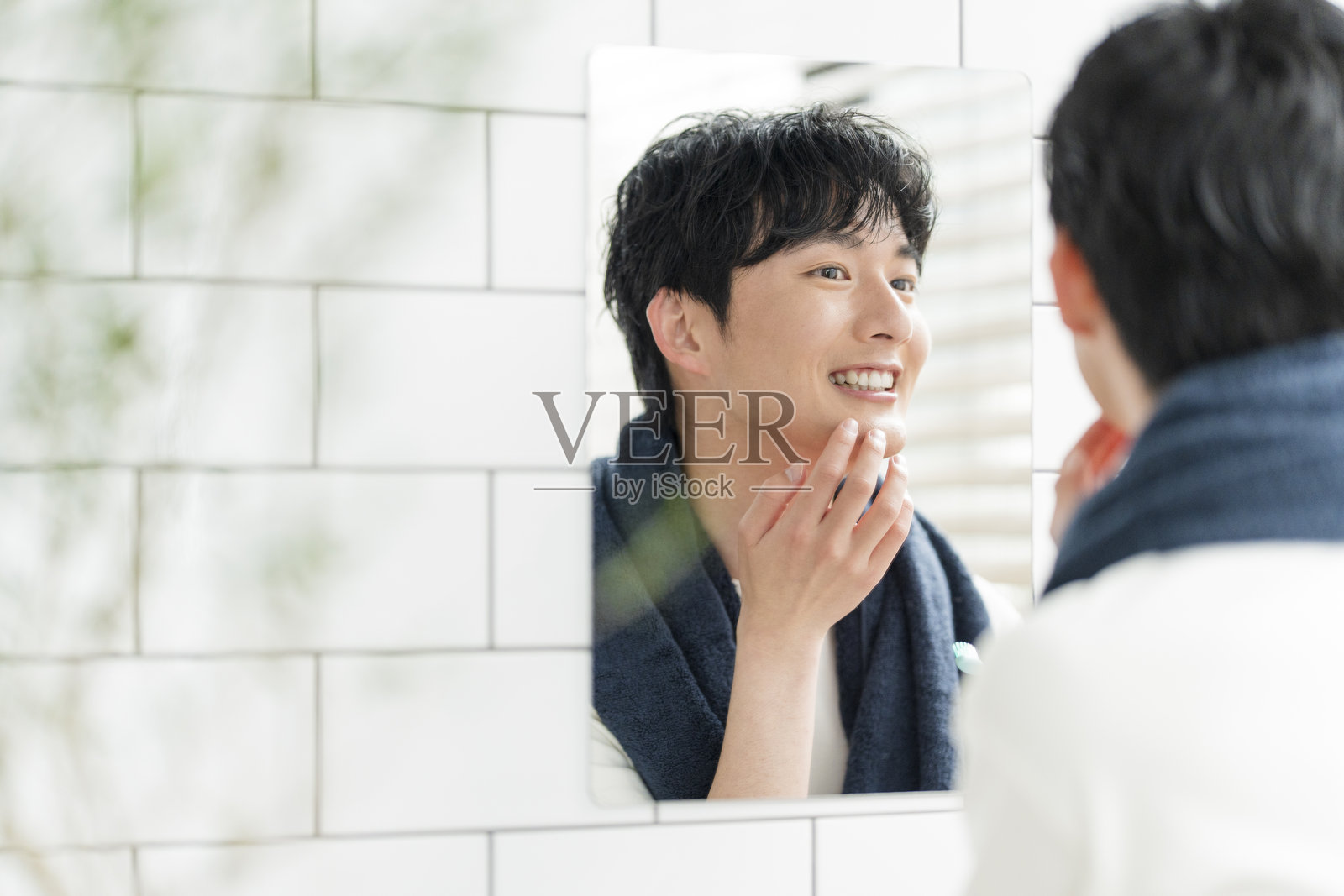 一位年轻的日本男子在家里的浴室里打理自己照片摄影图片