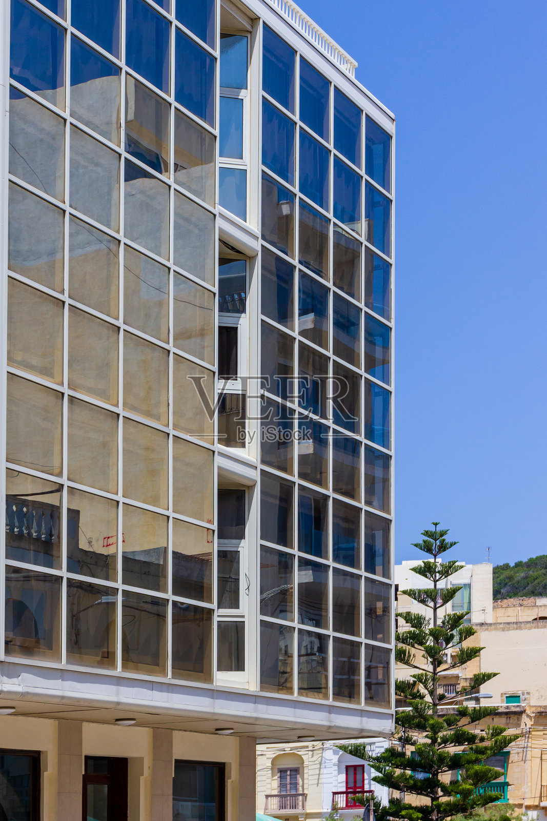 现代玻璃建筑在城市环境中反射蓝天照片摄影图片