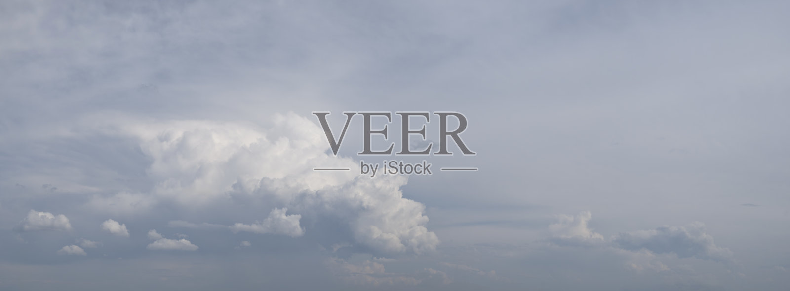 天空多云,云朵是白色的。天空大部分是蓝色,散布着几朵云。照片摄影图片