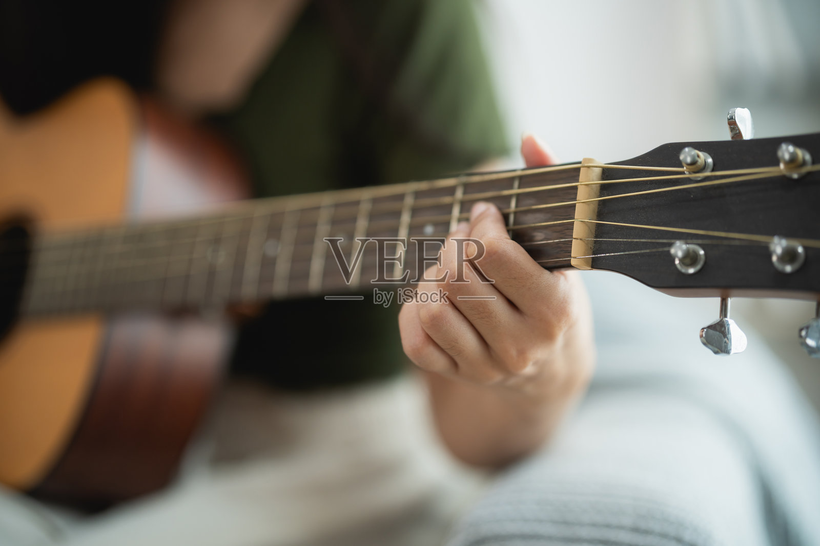 在轻松的室内环境中弹奏原声吉他的人照片摄影图片