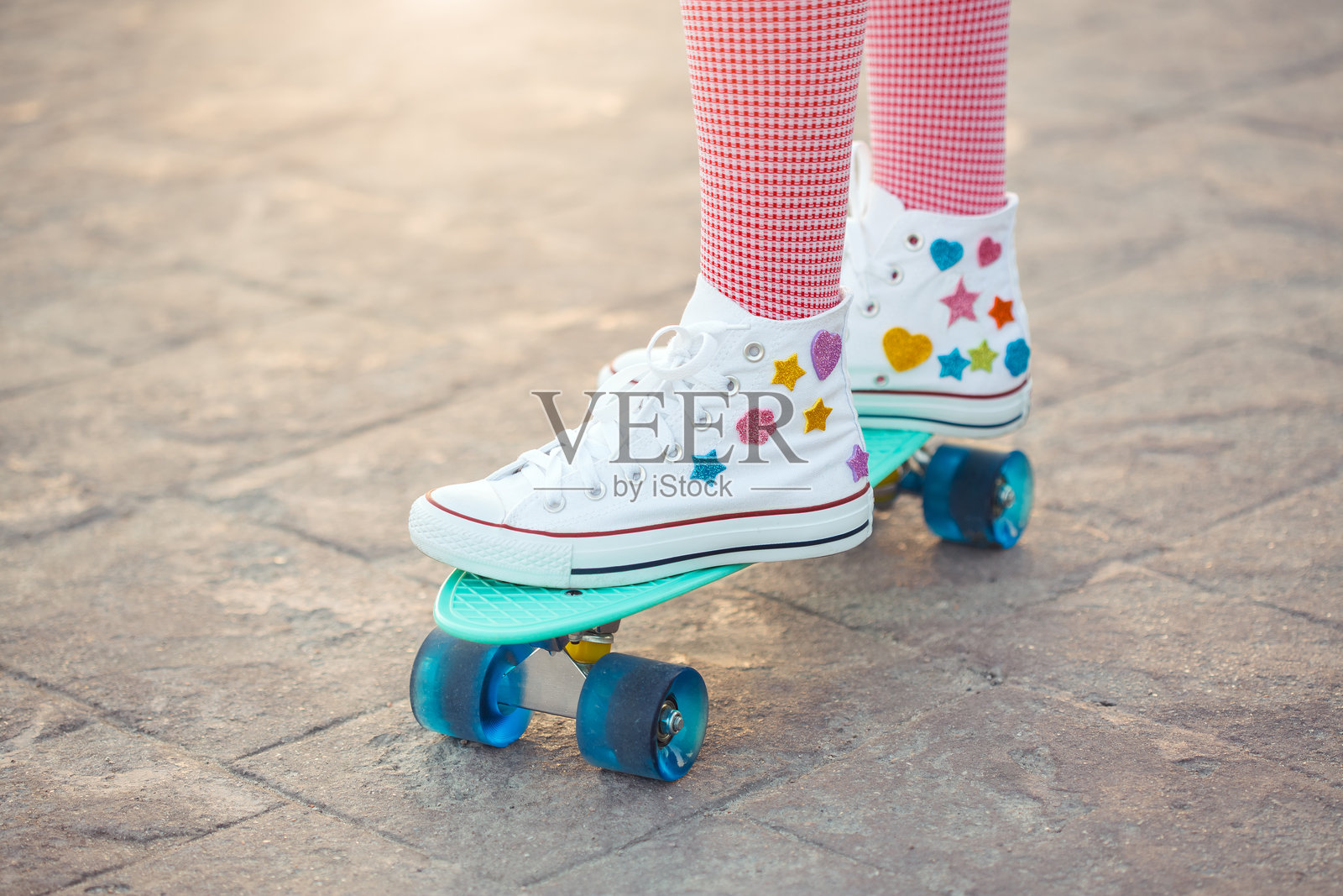 色彩缤纷的复古运动鞋和迷你滑板在充满趣味的户外环境中照片摄影图片