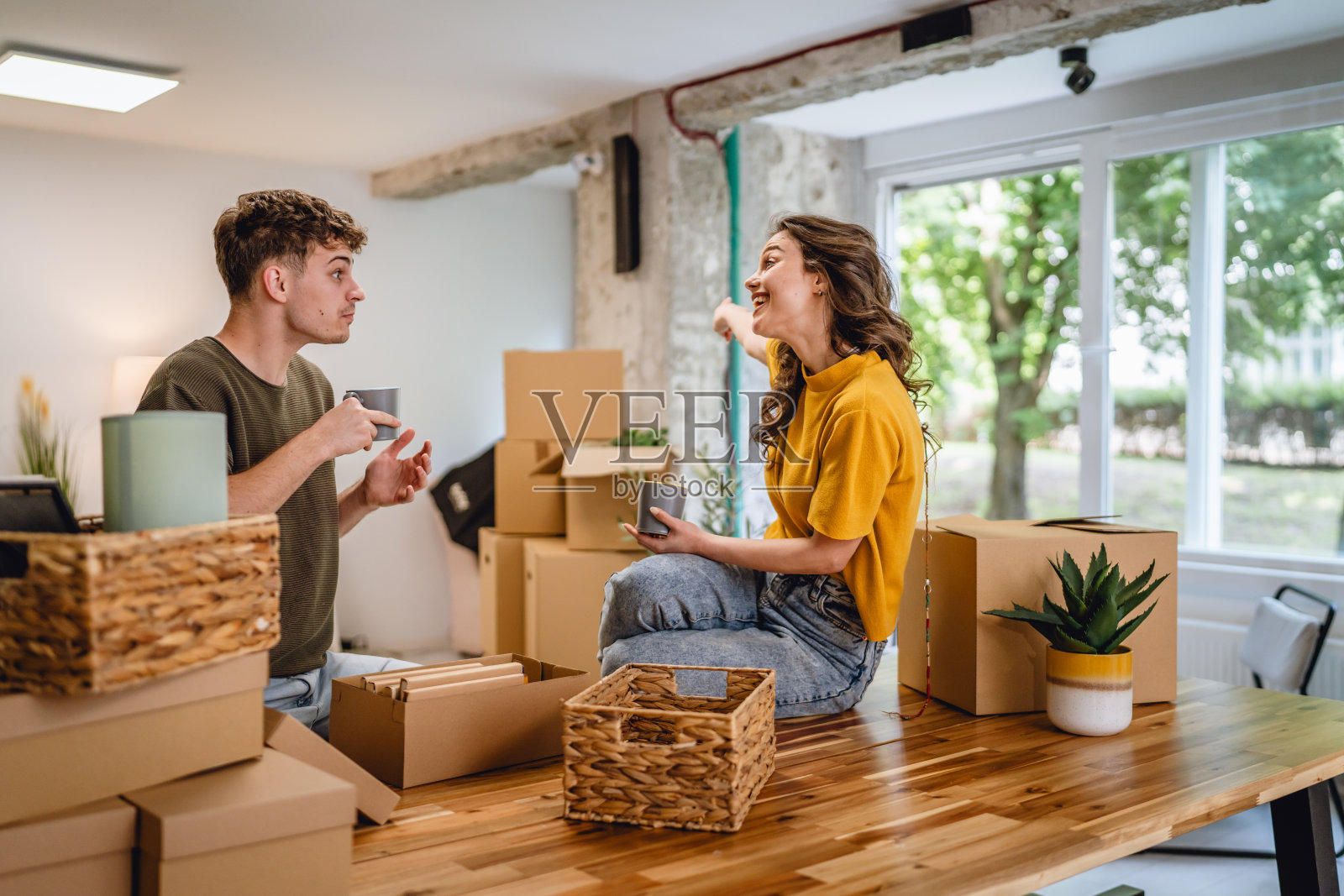 快乐的情侣一起拆箱子,享受咖啡时光。照片摄影图片