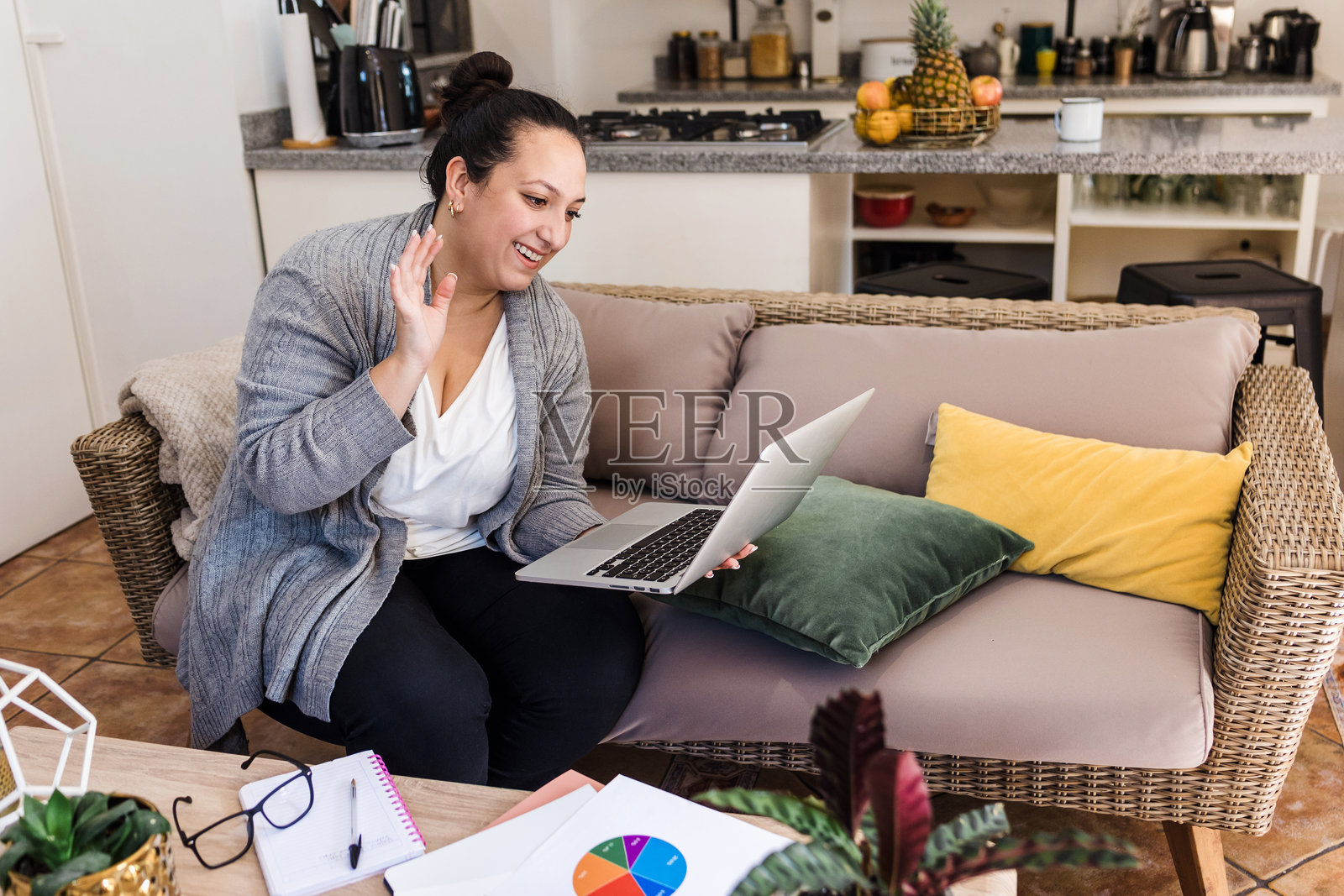 年轻的拉丁裔丰满女性在墨西哥的家中坐在沙发上使用笔记本电脑工作照片摄影图片