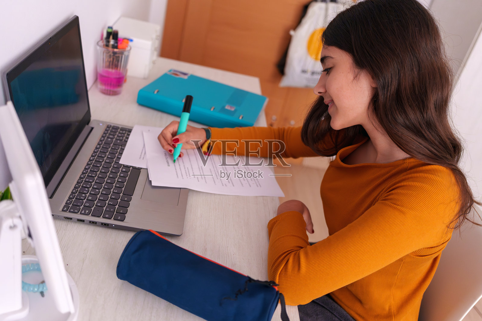 在家用笔记本电脑和荧光笔做作业的少女照片摄影图片