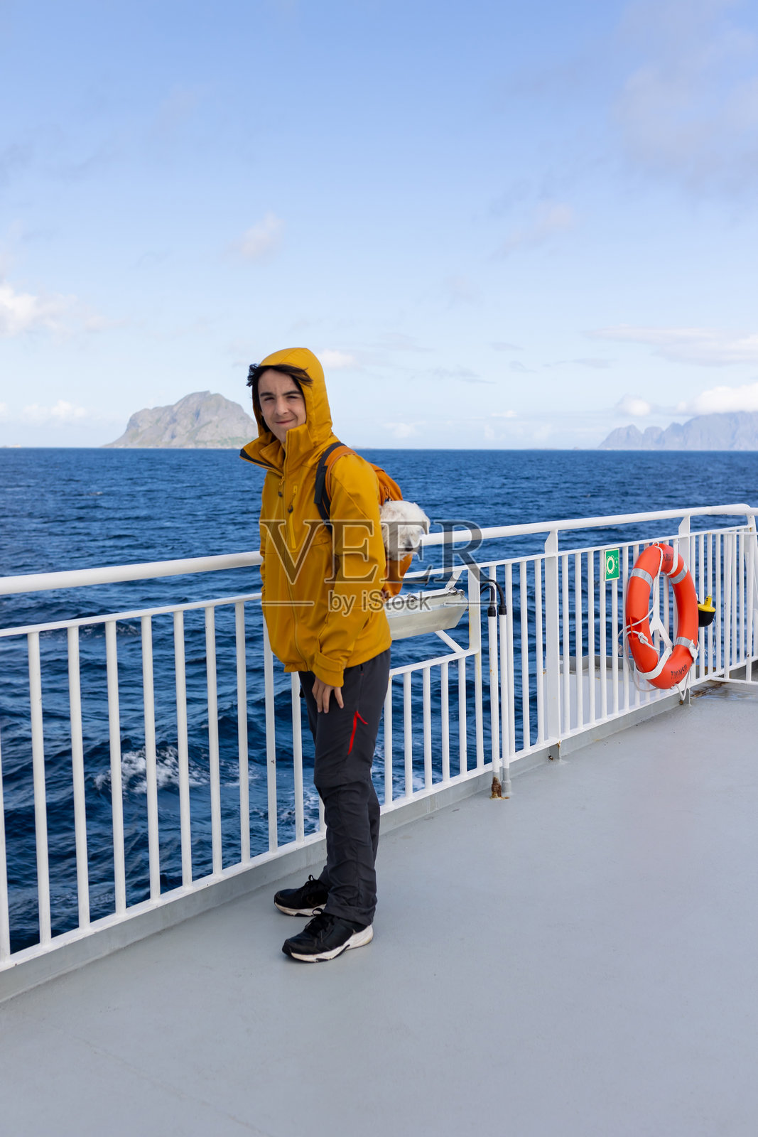 带着孩子和狗的家庭,乘坐渡轮从莫斯肯索亚前往瓦罗亚,狗在背包里。照片摄影图片