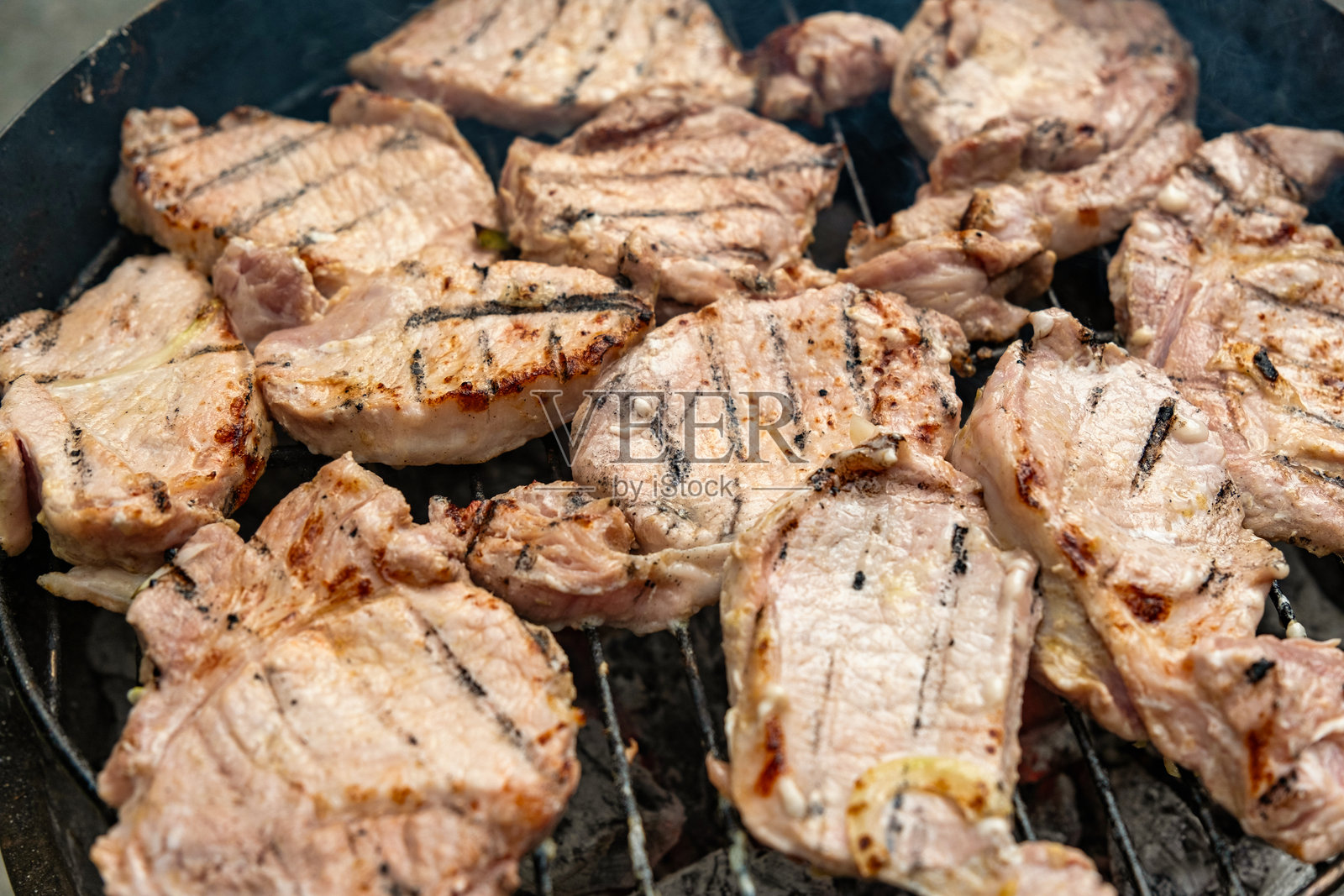 不锈钢烤架上的烤肉牛排,背景为黑色火焰。美食和烹饪概念。照片摄影图片