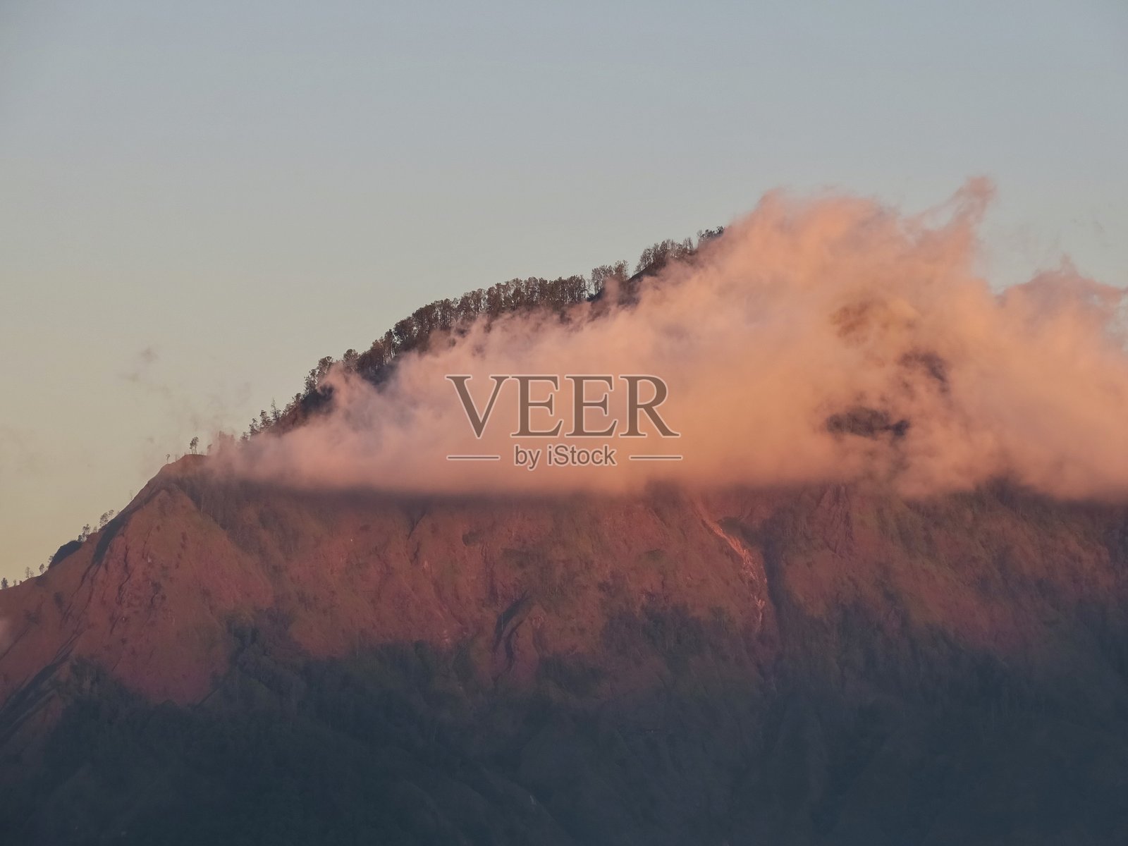 日落时云雾缭绕的山顶照片摄影图片