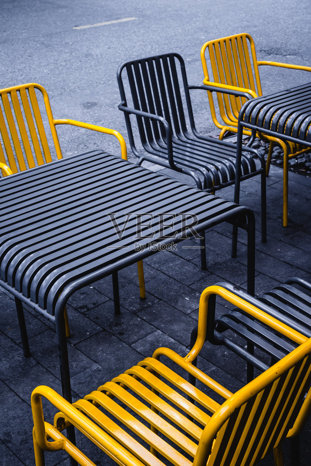 户外城市环境,铺有黄黑相间金属椅子的路面照片摄影图片