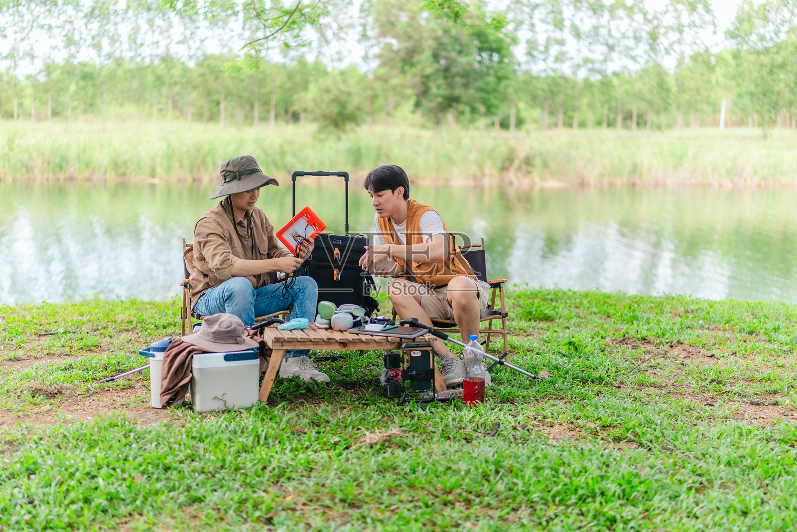 在湖边野餐时用太阳能为手机充电照片摄影图片