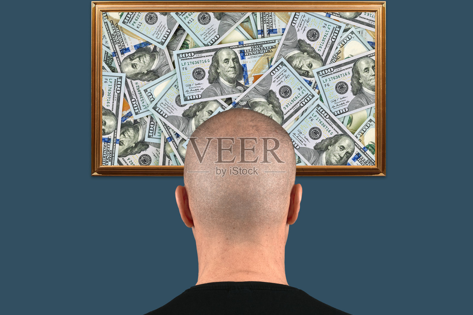 秃头男子凝视着蓝色背景上装框的美国百元钞票拼贴画。关于对金钱的痴迷、财务目标或财富愿景的概念。照片摄影图片