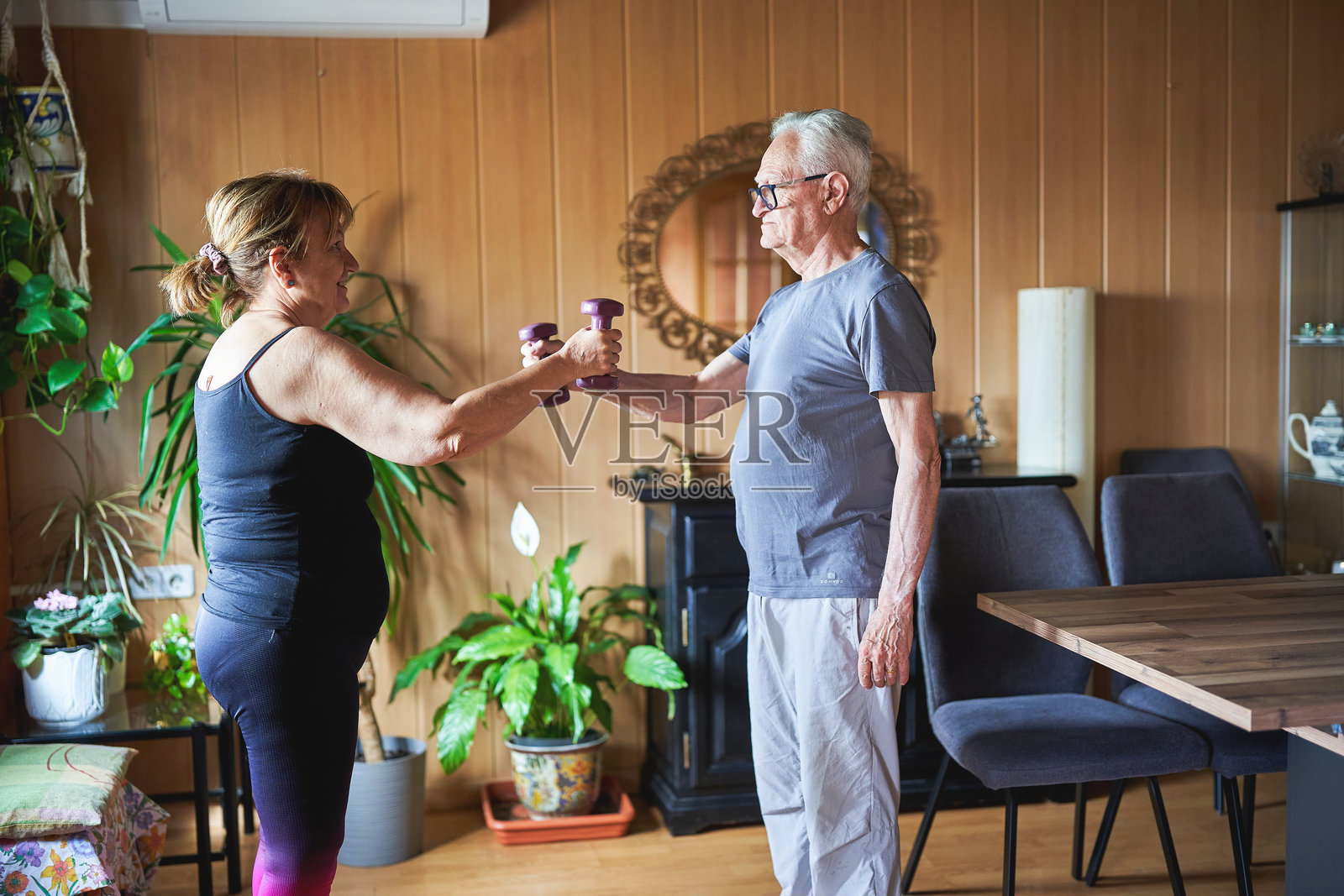 老年夫妇在家一起用哑铃锻炼照片摄影图片
