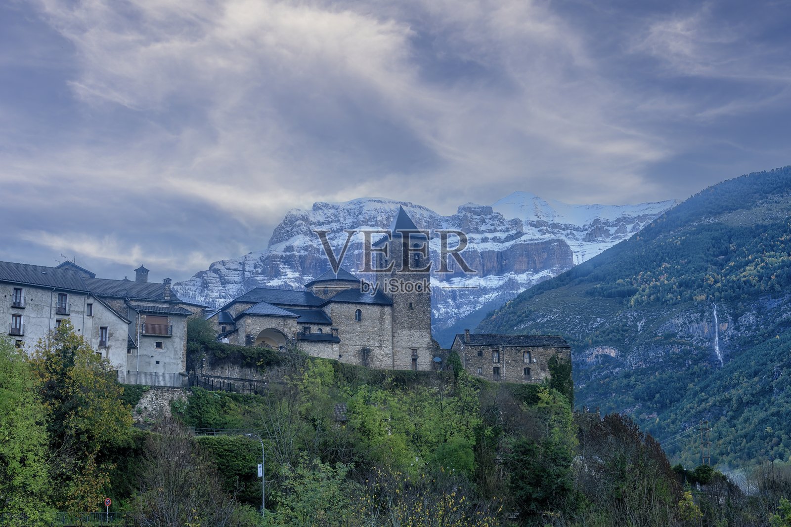 托尔拉 - 乌埃斯卡的中世纪石教堂与雪山照片摄影图片