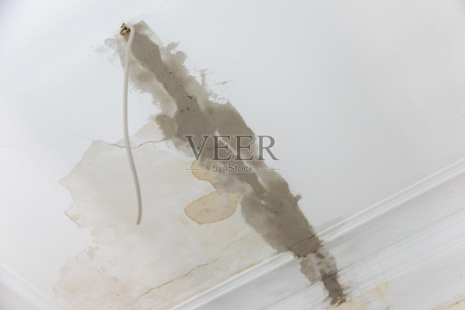 古老的历史性石膏天花板,带有灰泥图案,旁边是新装的电缆管道,刚刚抹好石膏。照片摄影图片